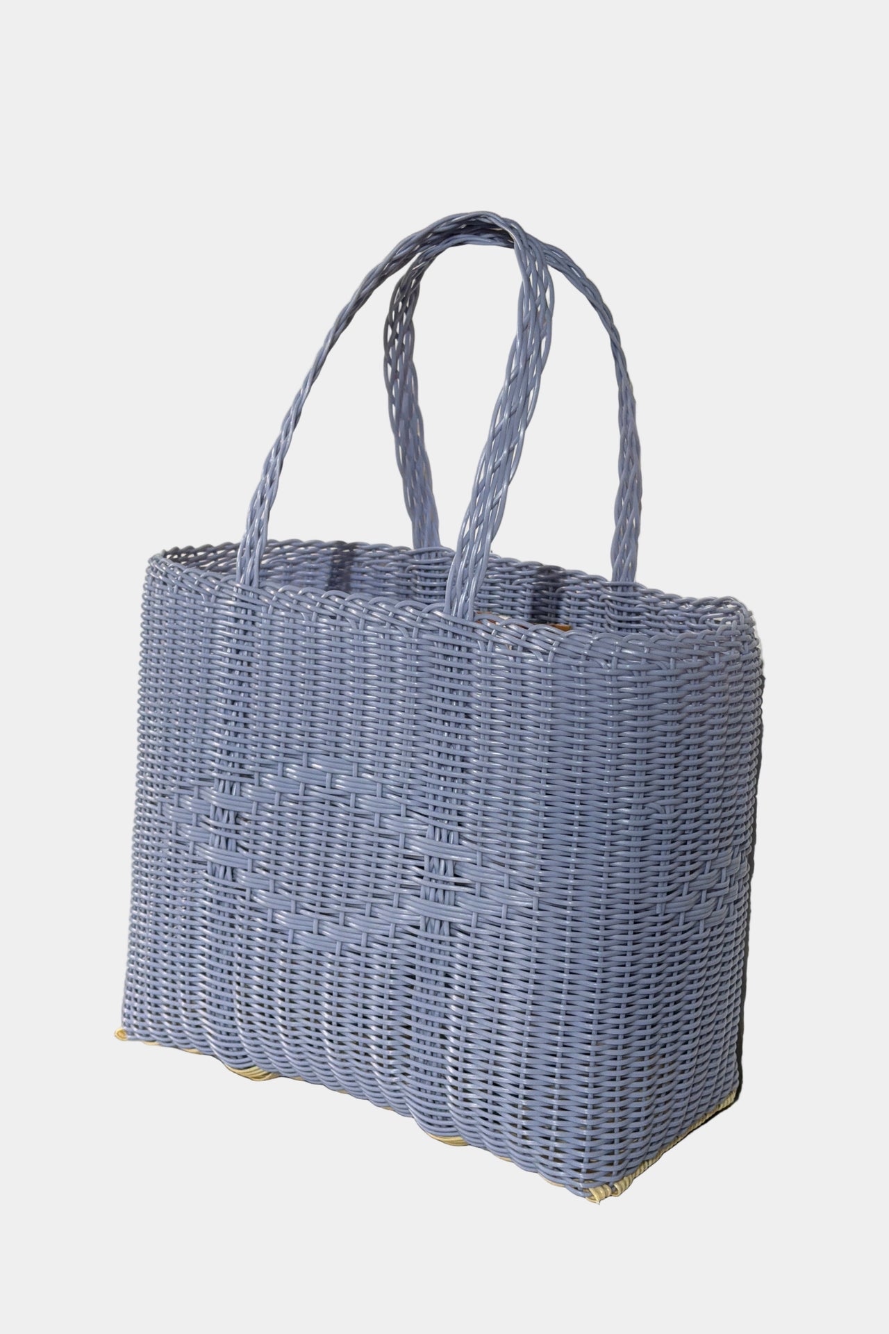 Woven blue handbag on a white surface