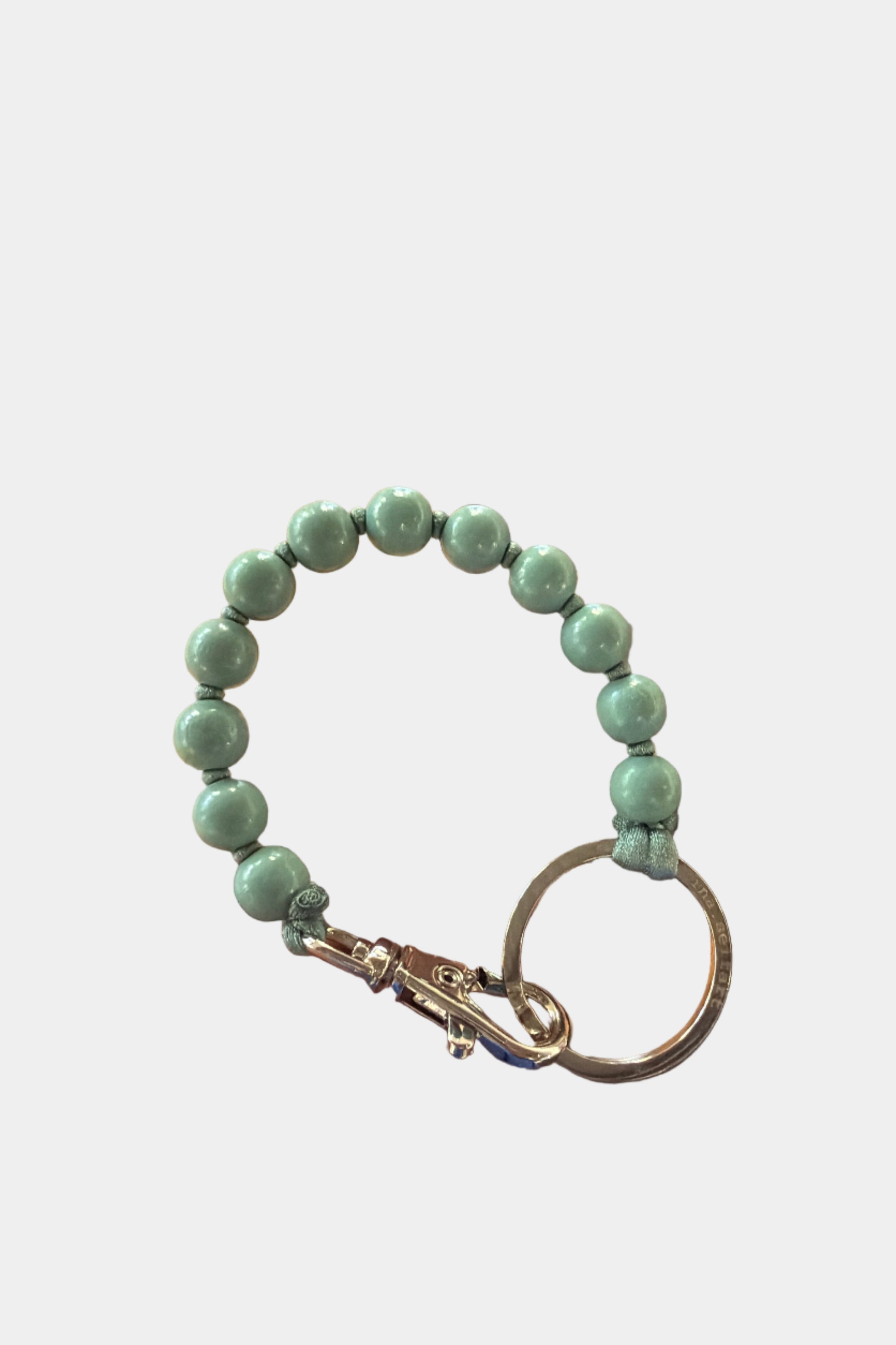 Green wooden beaded keychain on a white background
