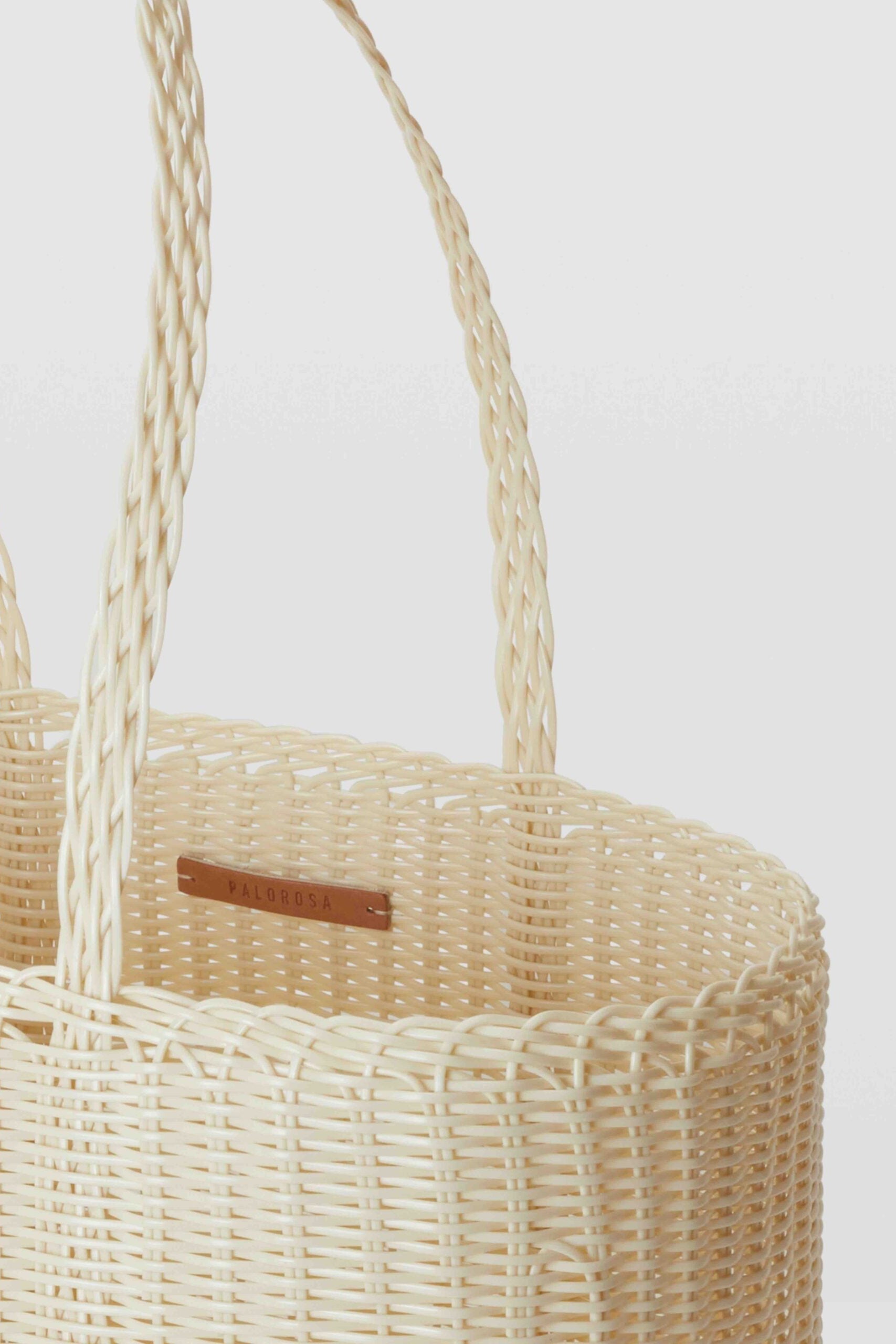 Woven basket with handles on a light gray background
