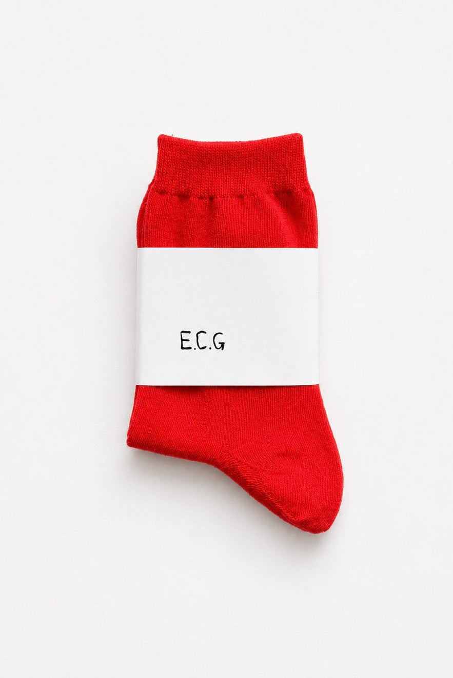 Red sock with a white label on a light gray background