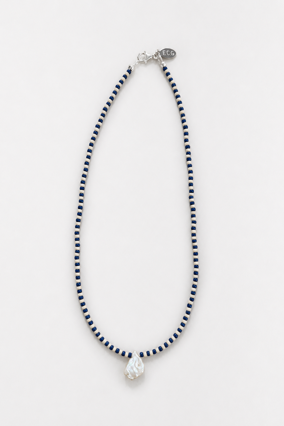 he No.11 beaded necklace in Navy Sand, showcasing the pattern of Japanese seed beads and a central single freshwater pearl - East Coast General