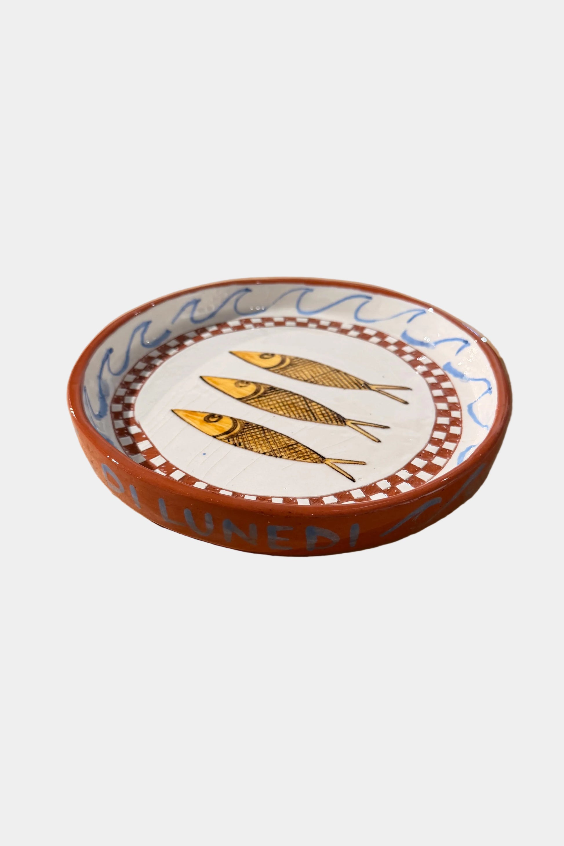 Decorative plate with 3 fish design on a plain surface