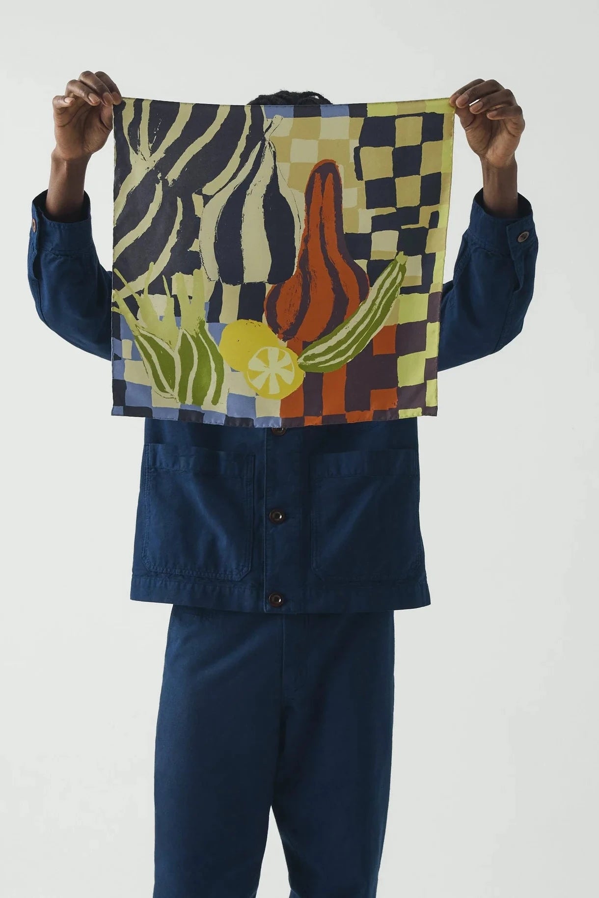 Person holding a colorful woven bag with abstract design against a white background