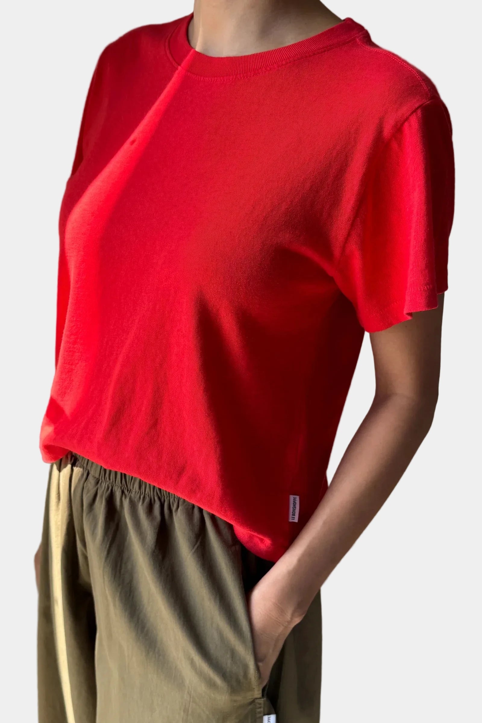 A person wearing the Le Bon Shoppe Airy Tee in tomato, viewed for the side - East Coast General