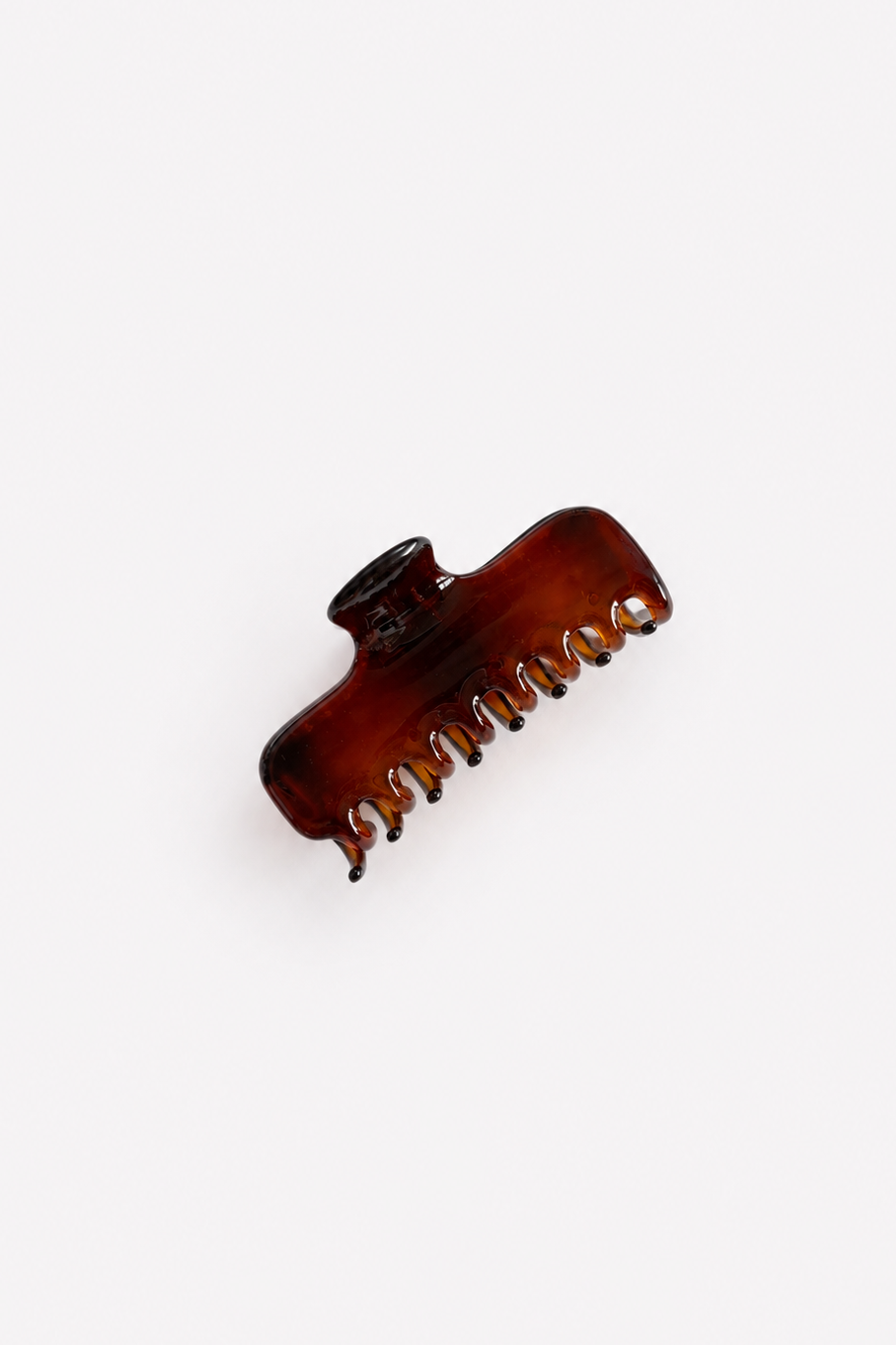 A single amber-brown translucent hair claw clip on a clean white background - East Coast General
