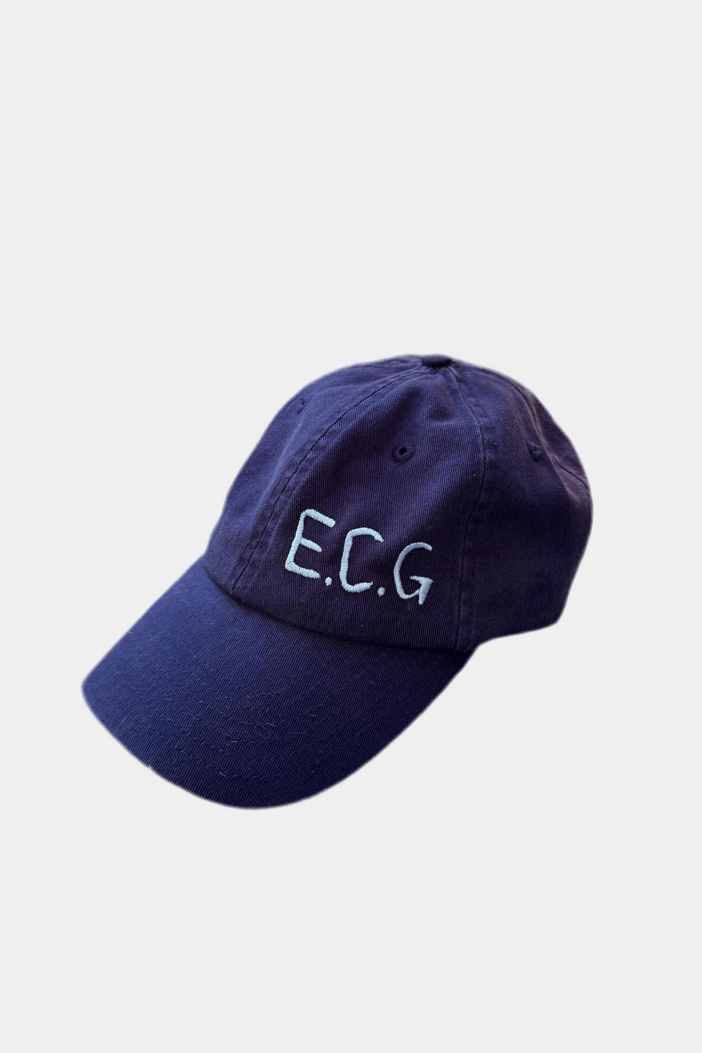 Navy blue cap with 'E.C.G.' text on a light gray background