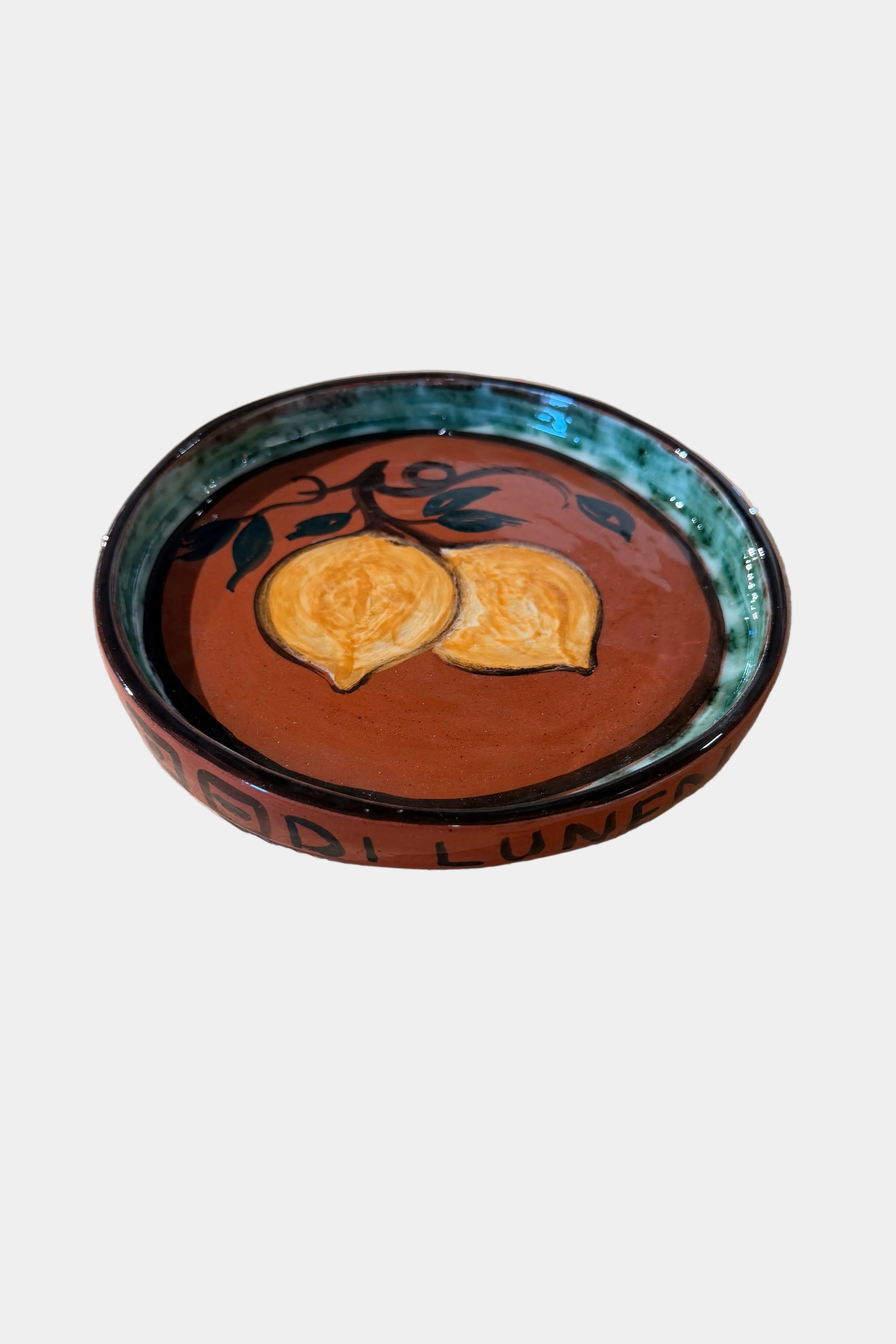 Ceramic plate with fruit design on a plain background