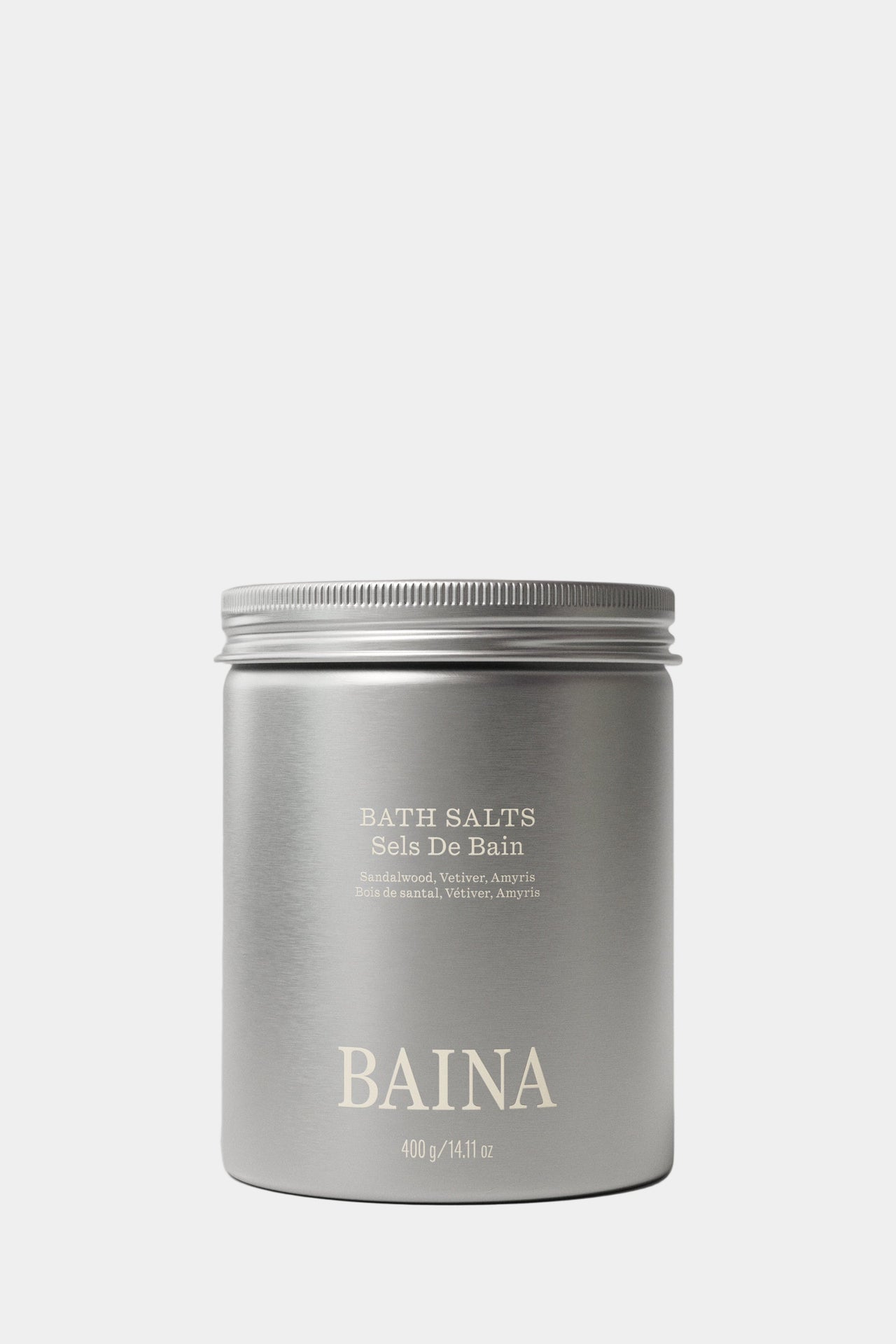 Silver container of BAINA bath salts on a gray background