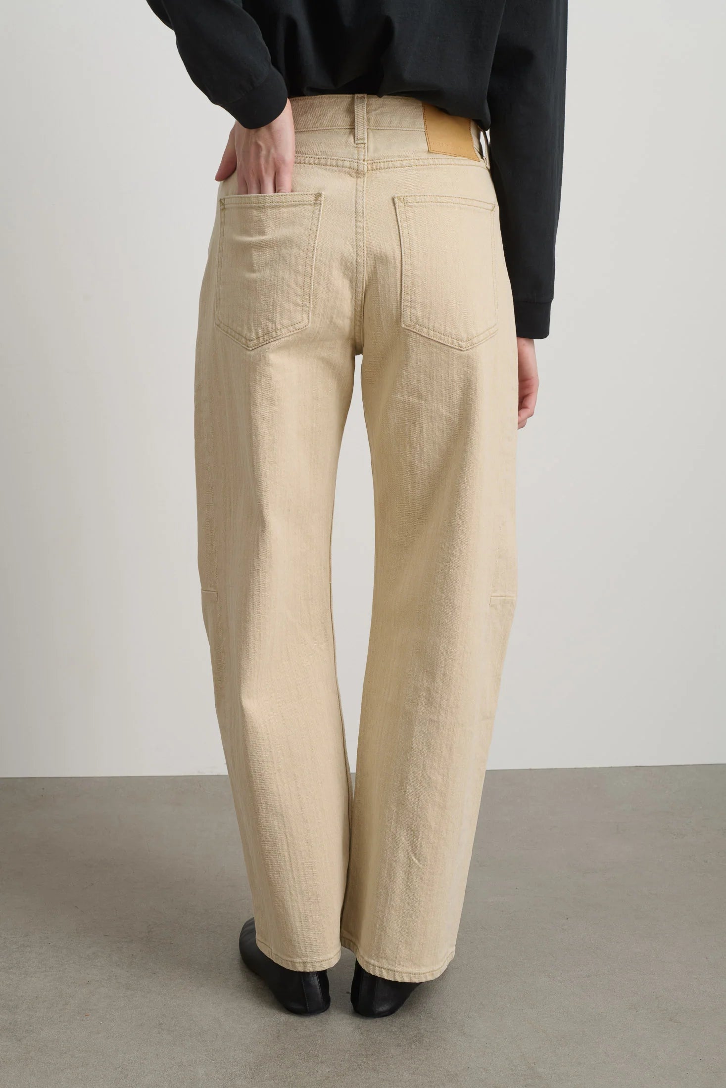 Person wearing beige corduroy pants against a plain background