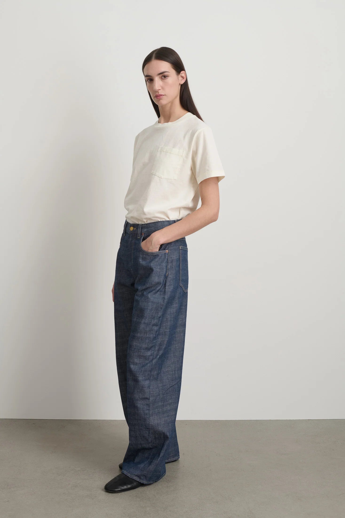 Person wearing a white t-shirt and blue jeans against a plain background