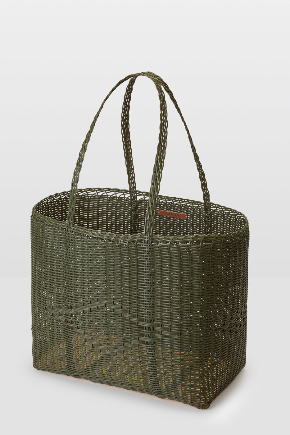 Green woven basket with handles on a light gray background