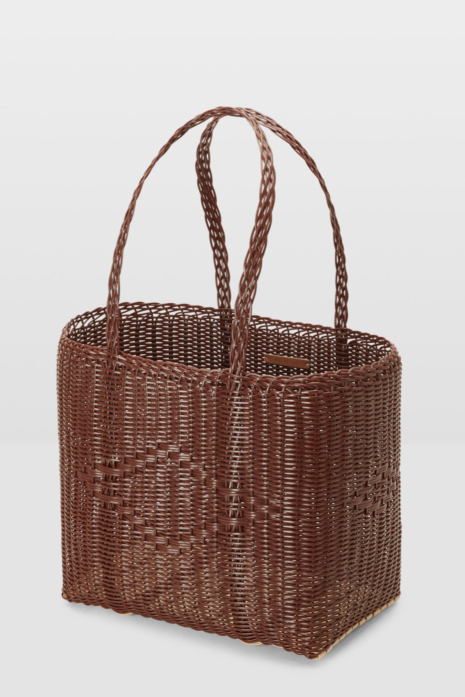 Brown woven basket with handles on a light gray background