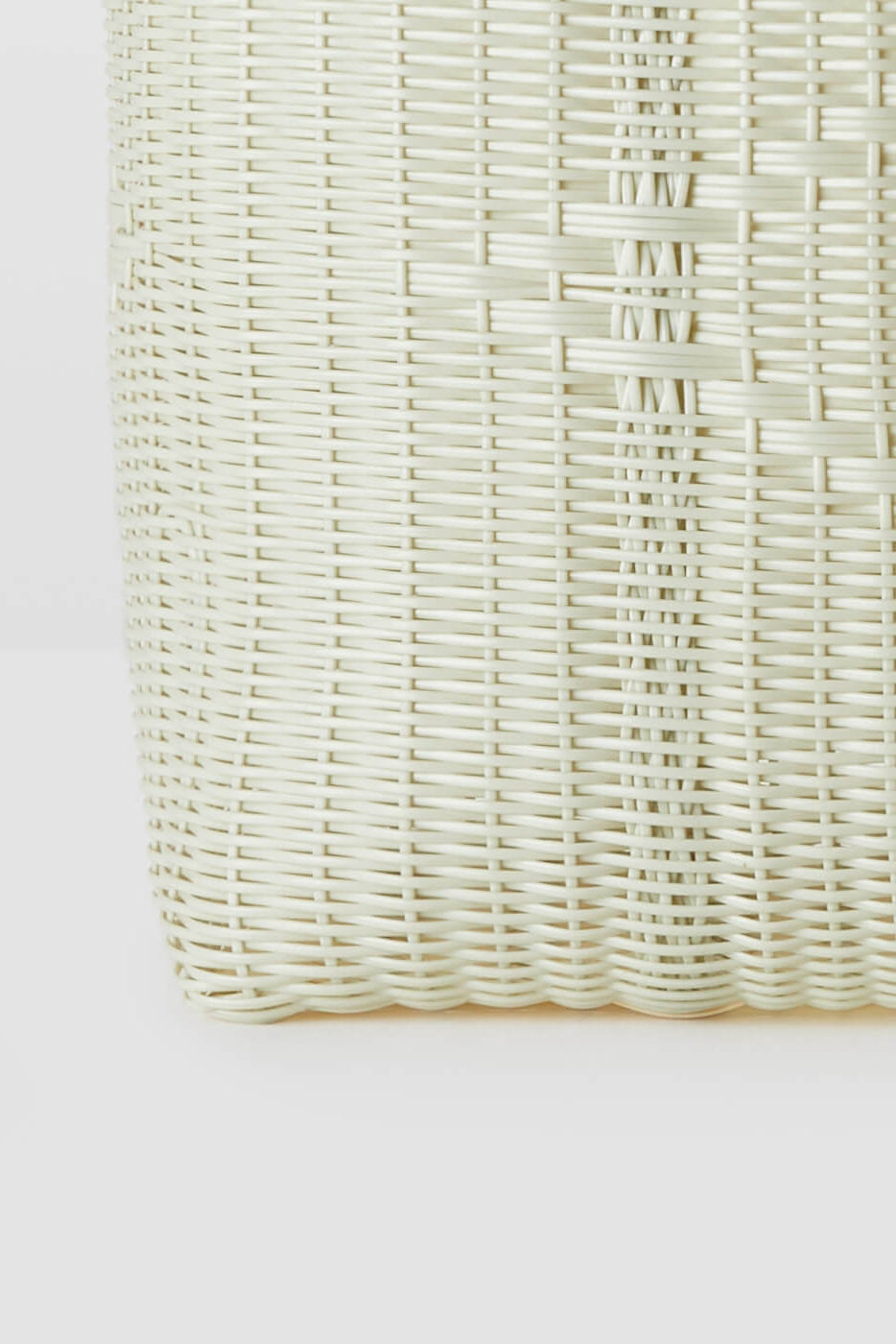 Close-up of a woven white basket on a light gray background