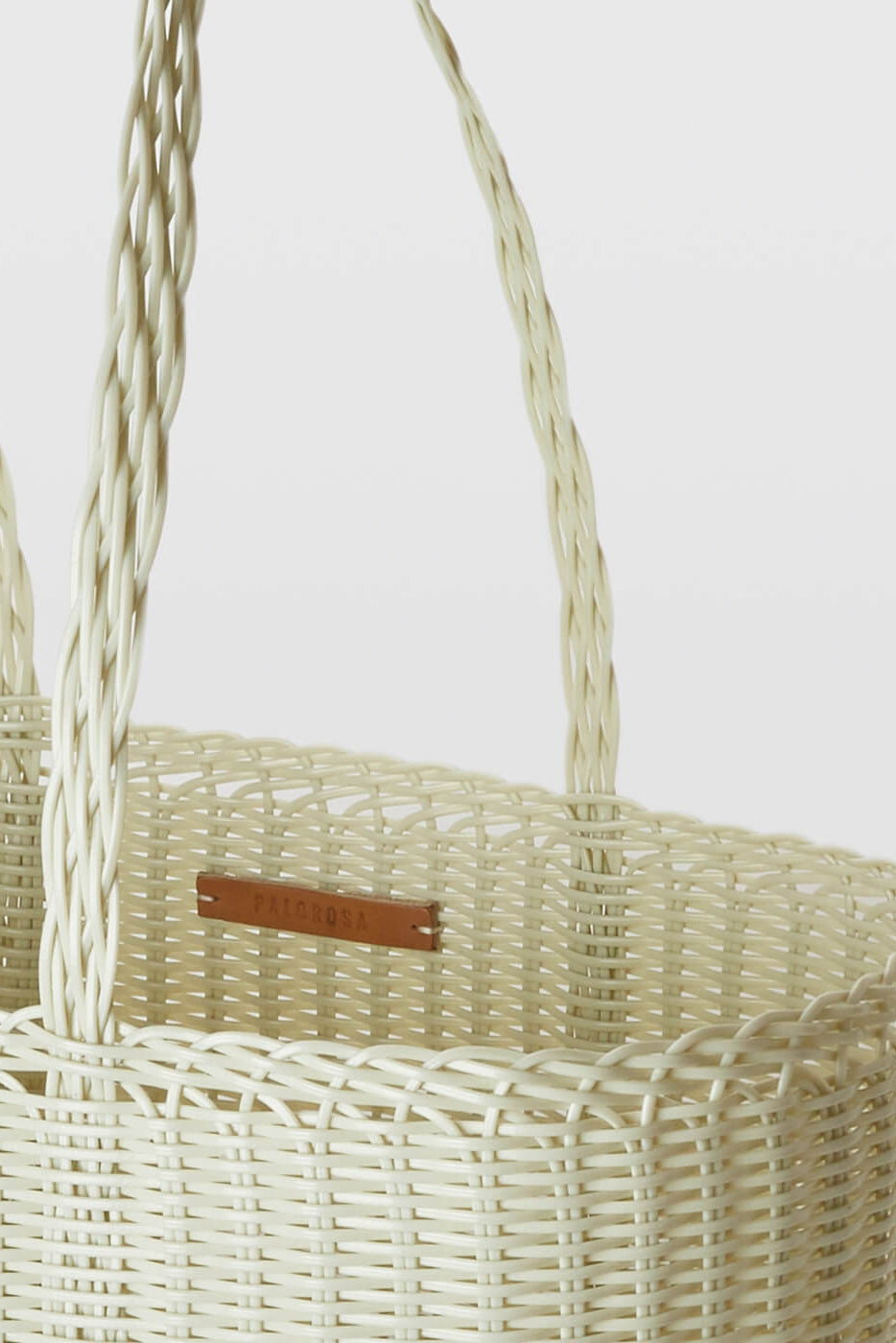 Woven basket with handles on a light gray background