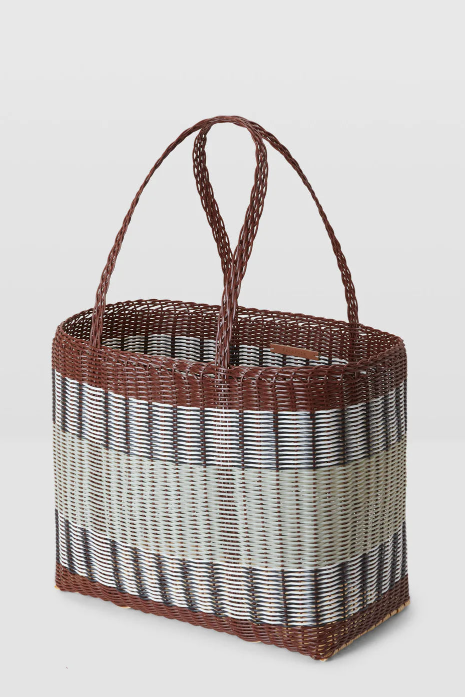 Woven basket with a gradient pattern on a light gray background