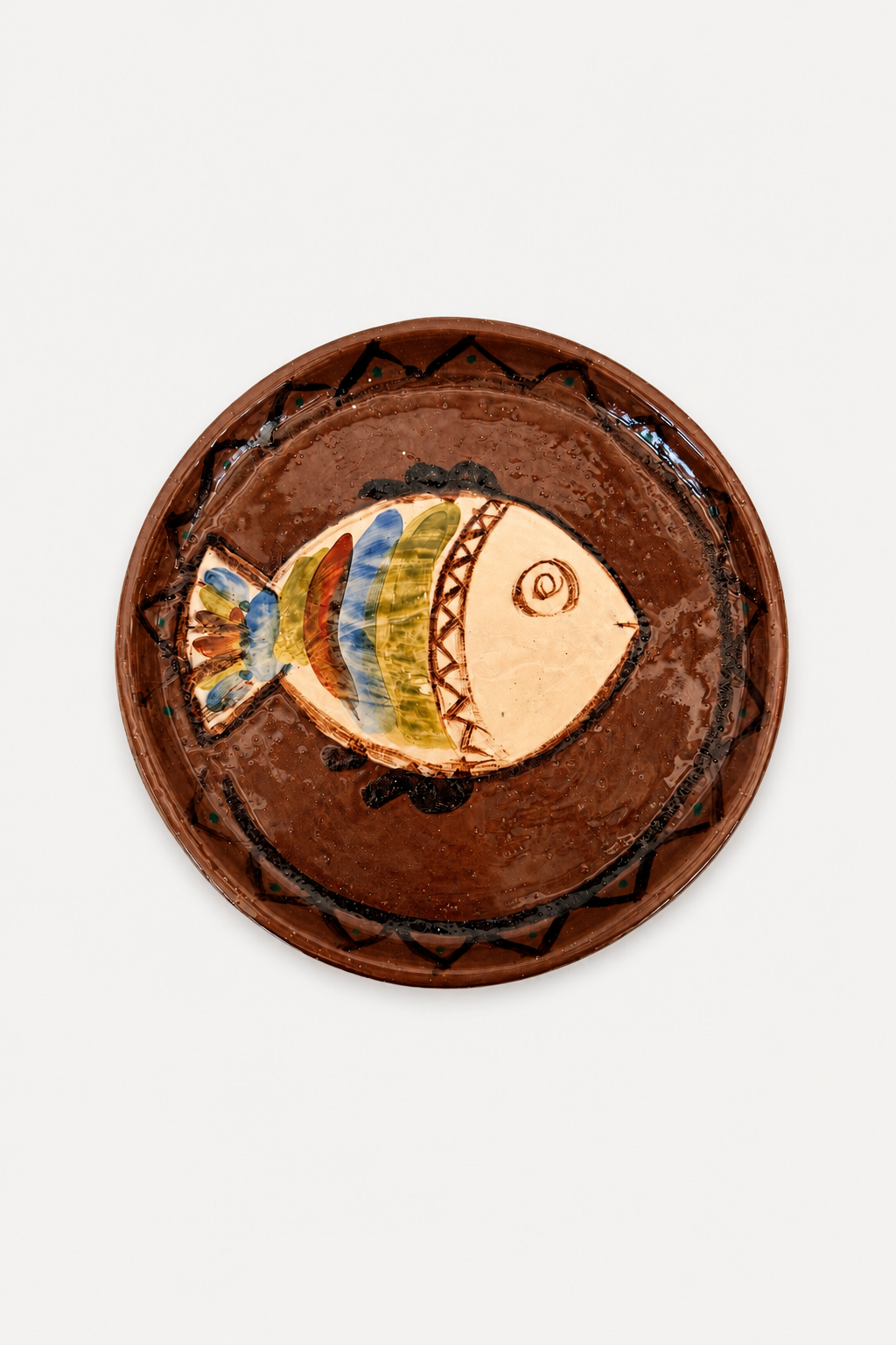 Di Lunedi sardine plate featuring a hand-painted fish design in the center with blue, green, and gold accents, set against a plain white background.