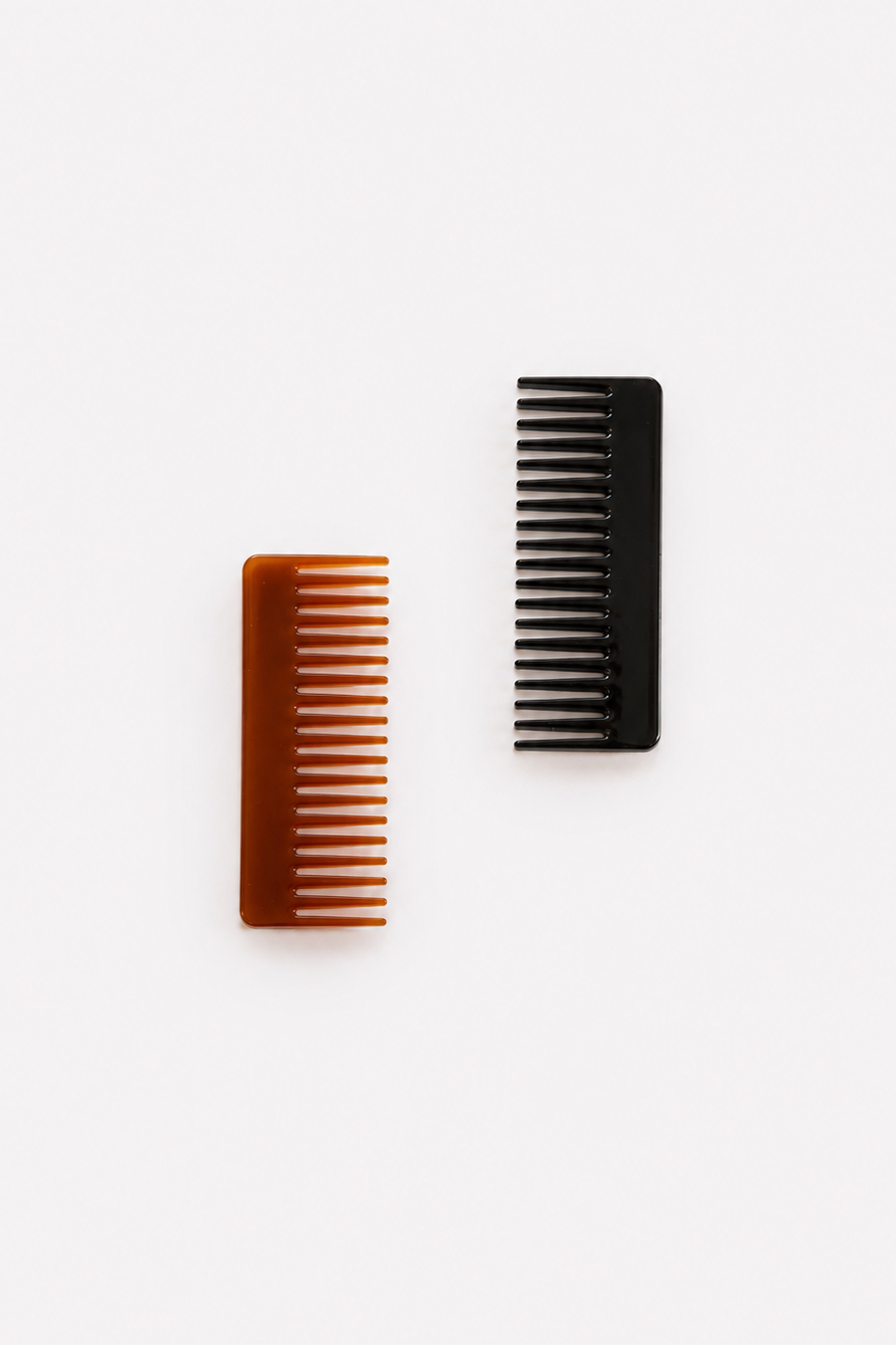Two rectangular hair combs on a plain white background: one in amber-brown and one in black - East Coast General