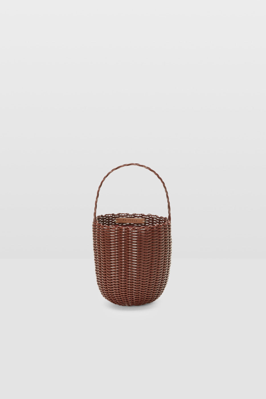 Woven basket with handle on a light gray background