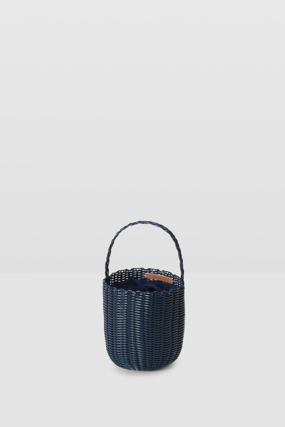 Black woven basket with handle on a light gray background