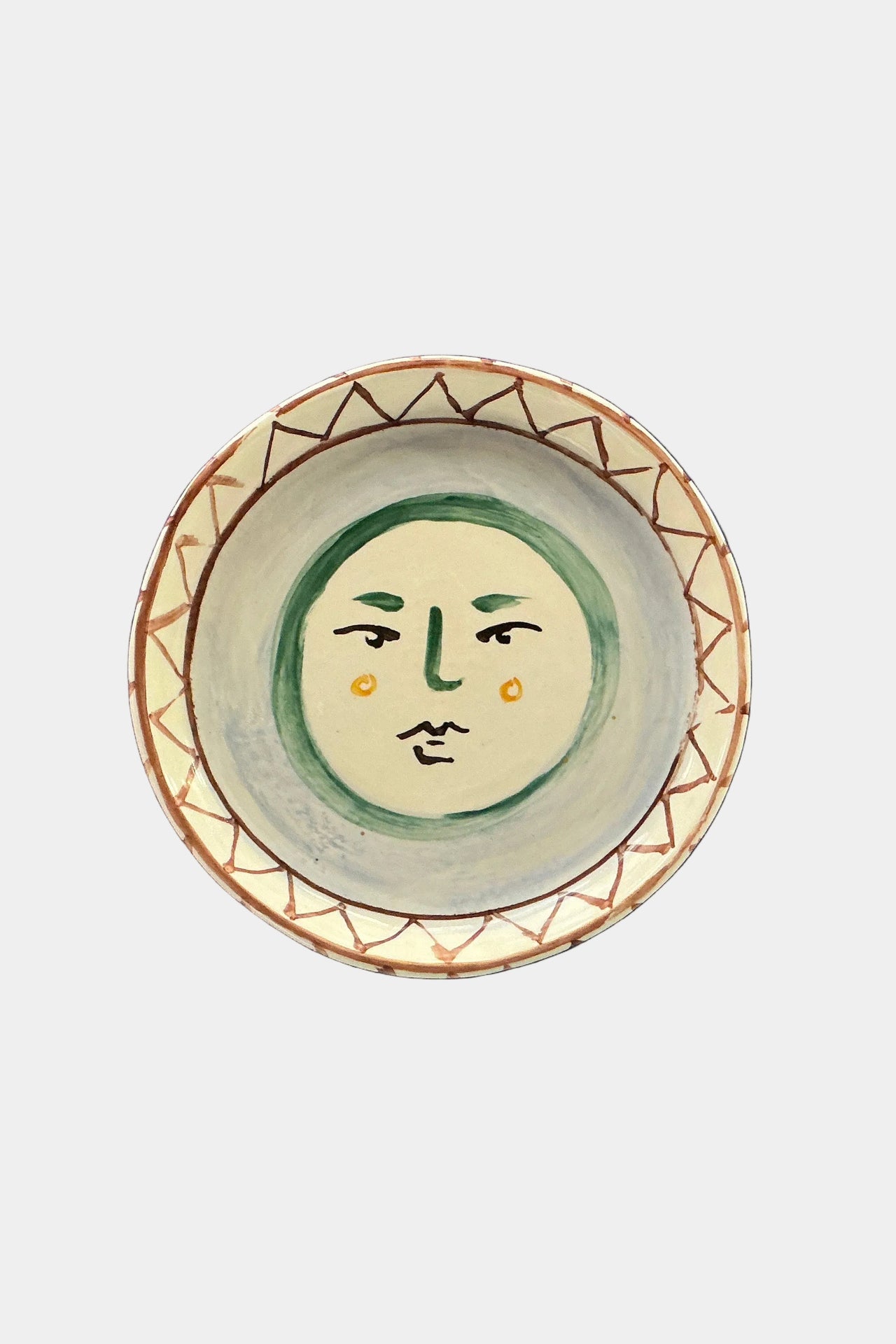 Ceramic plate with face design on a white background