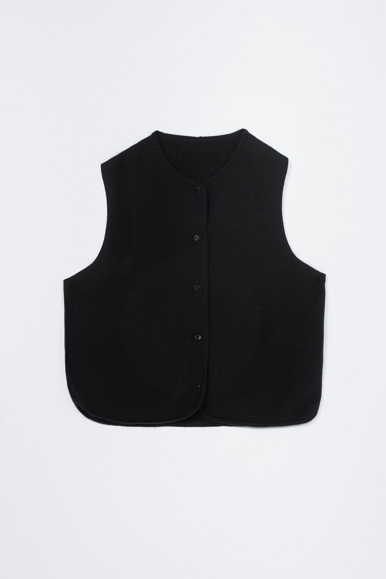 Person wearing a black sleeveless top and black pants on a white background