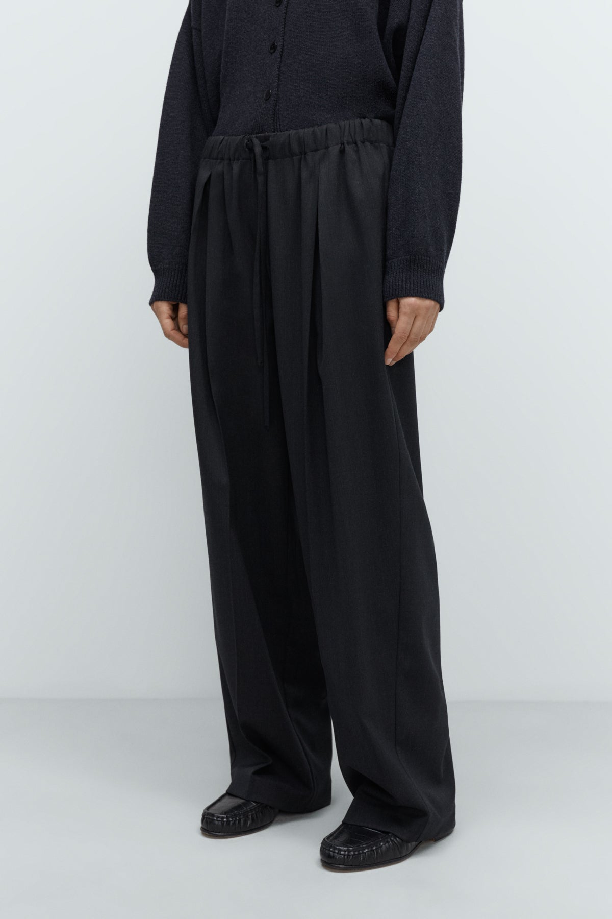 Person wearing a black outfit on a white background