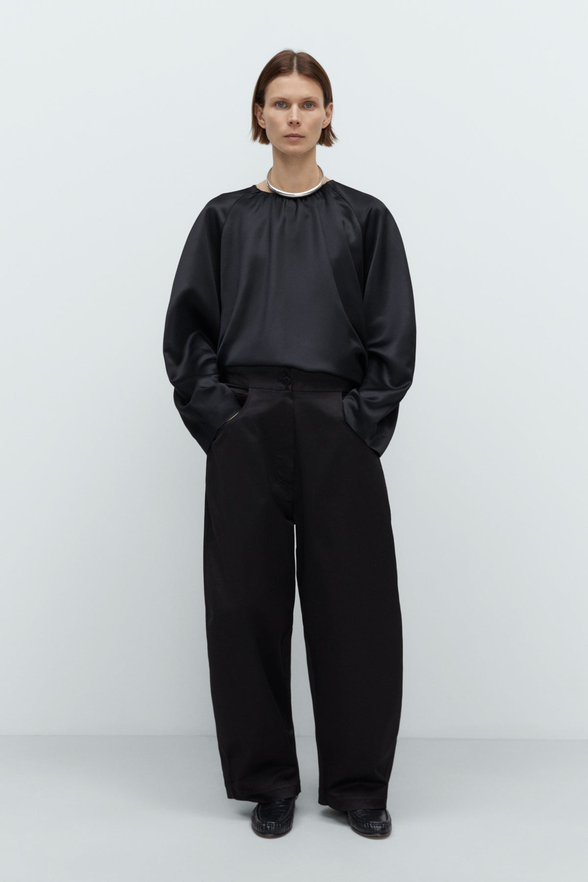 Person wearing a black outfit on a white background