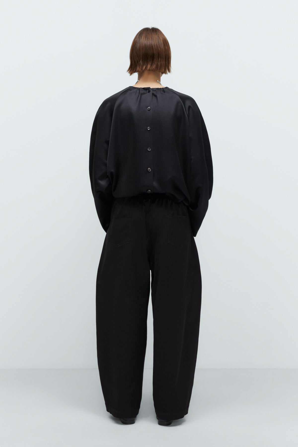 Person wearing a black outfit on a white background