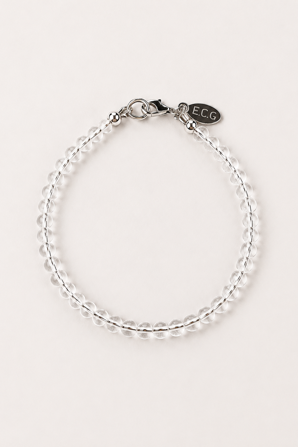 Clear quartz bracelet with silver hardware on a plain background 

