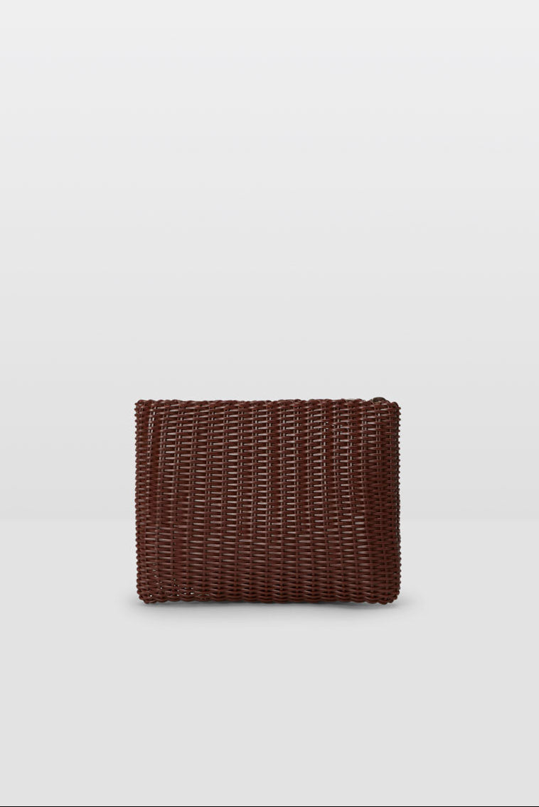 Brown small woven clutch on a grey background