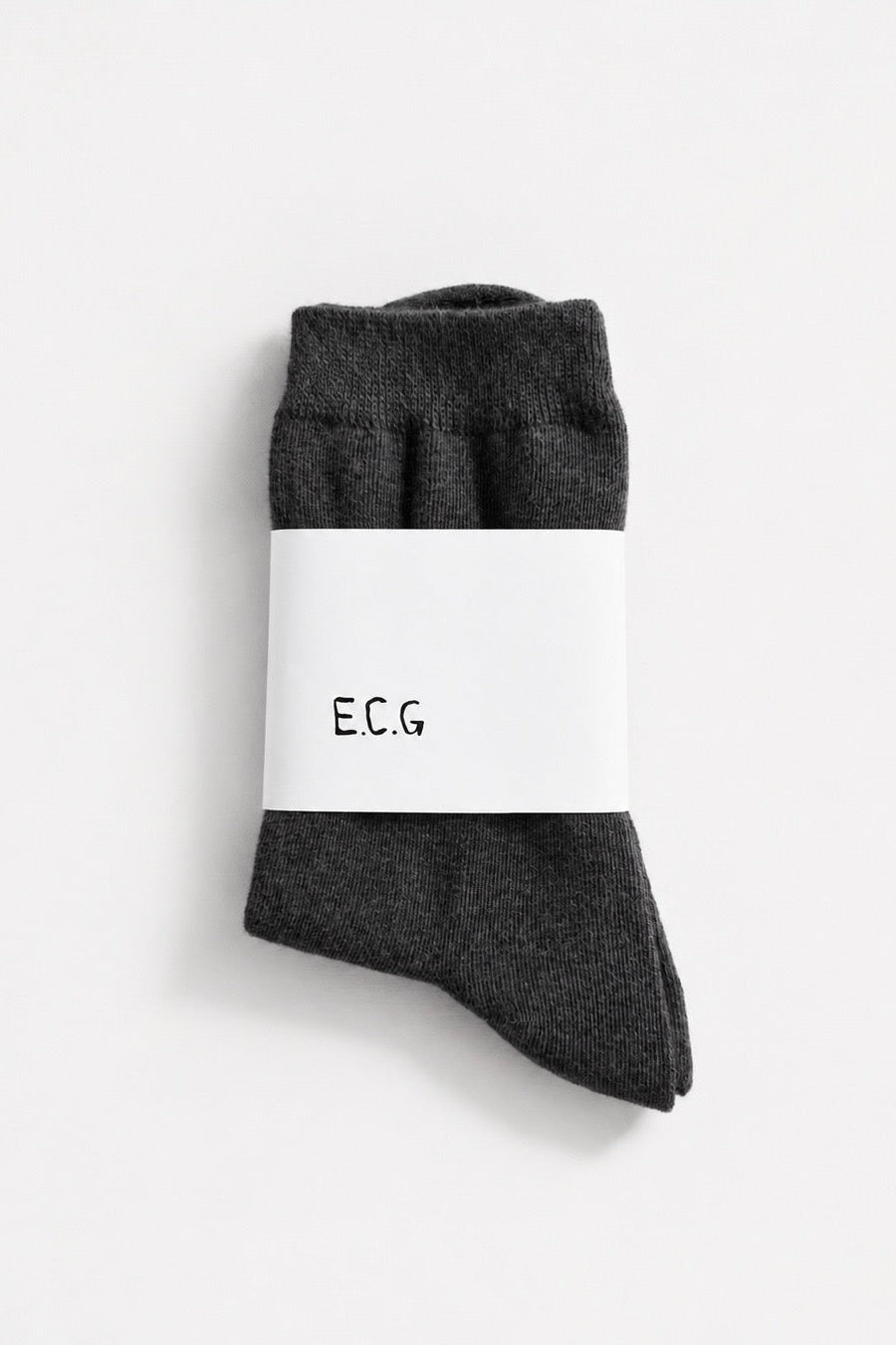 Dark gray socks with a white label on a light gray background