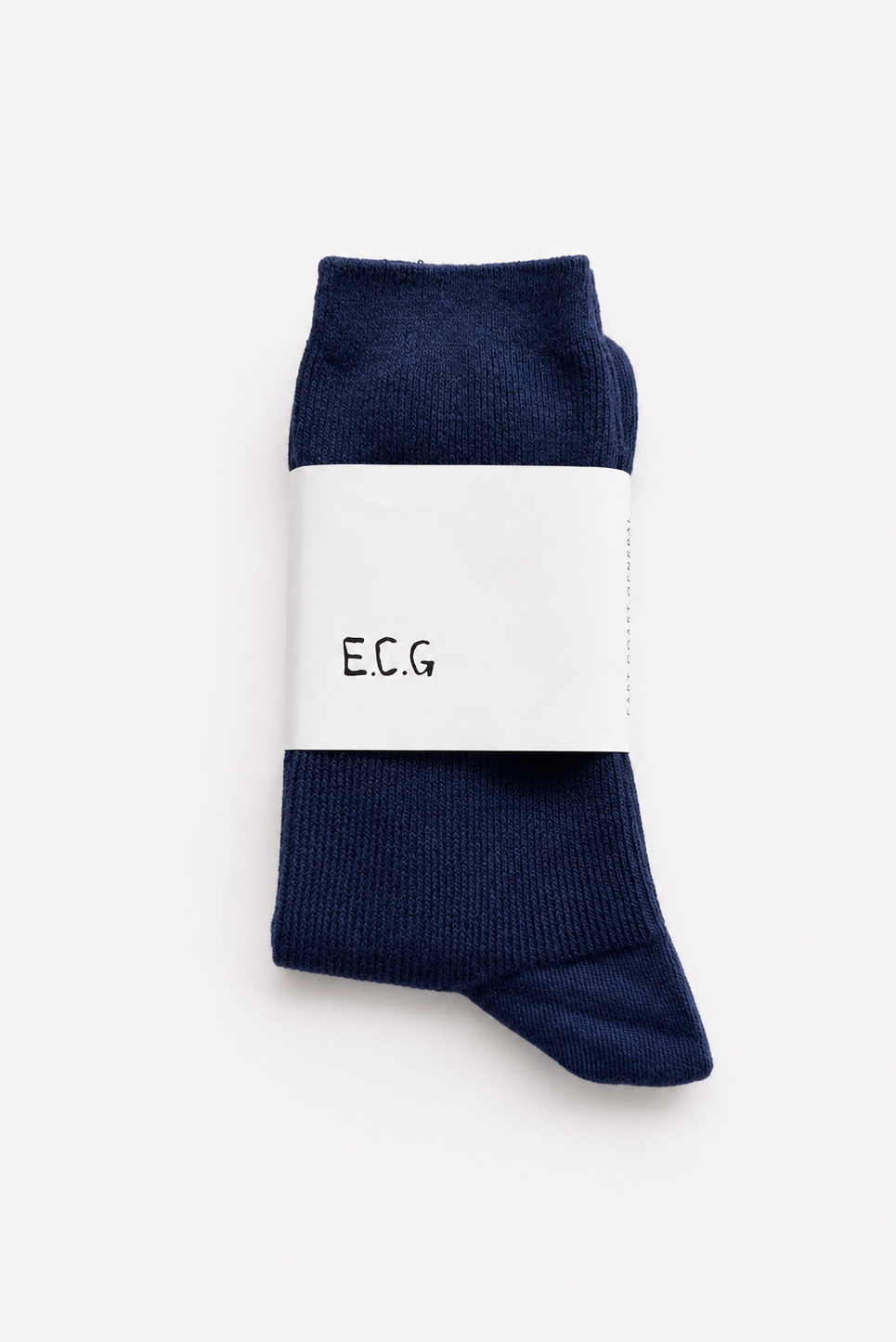 A pair of navy blue cotto ribbed crew socks folded together with a white paper band around the middle that reads 'E.C.G’ - East Coast General