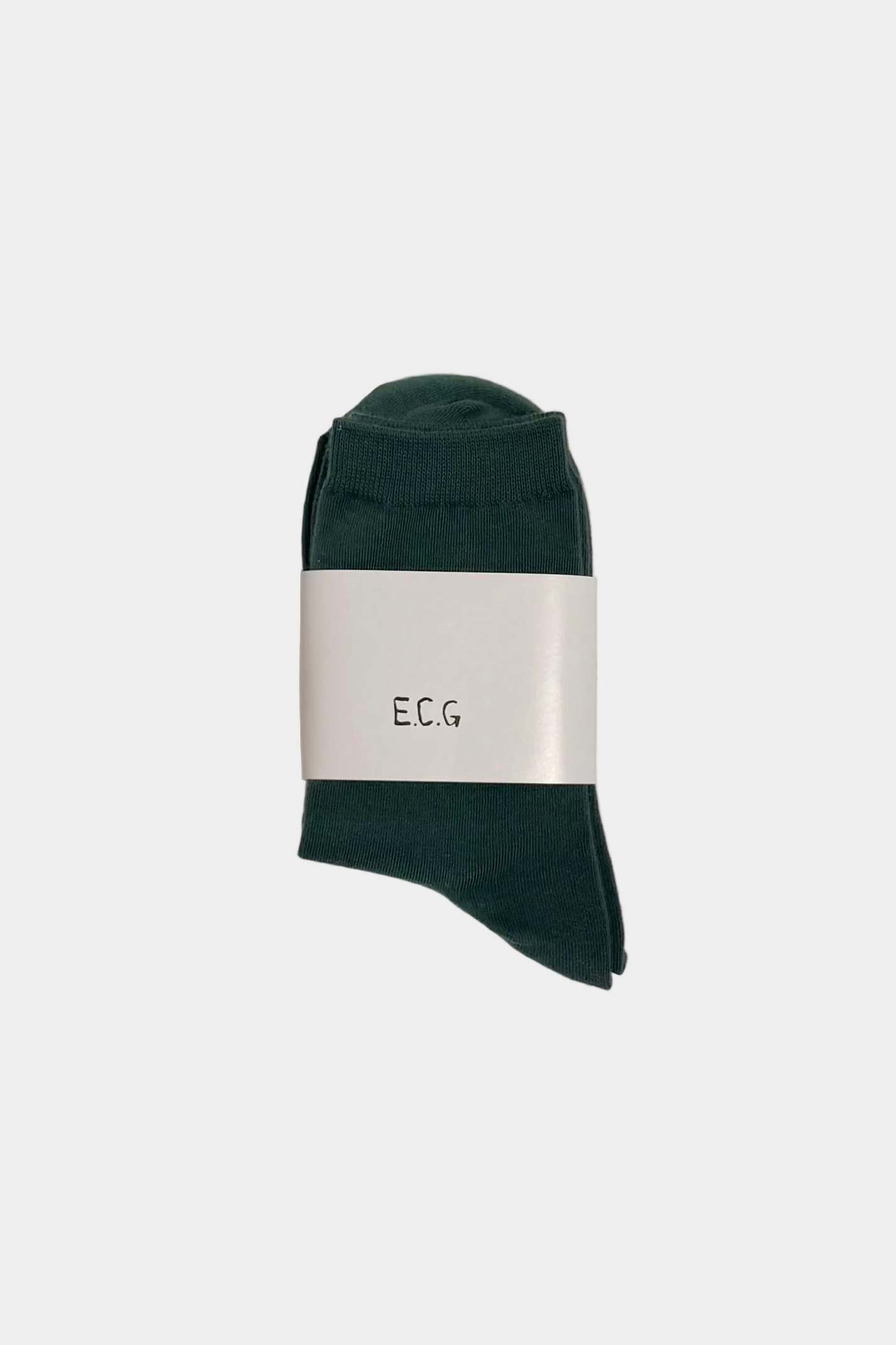 Green sock with a white label on a plain background