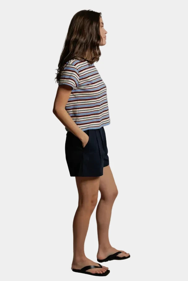 A person wearing the Dawn tee in pacific clementine stripe and black shorts, viewed from the side- east coast general