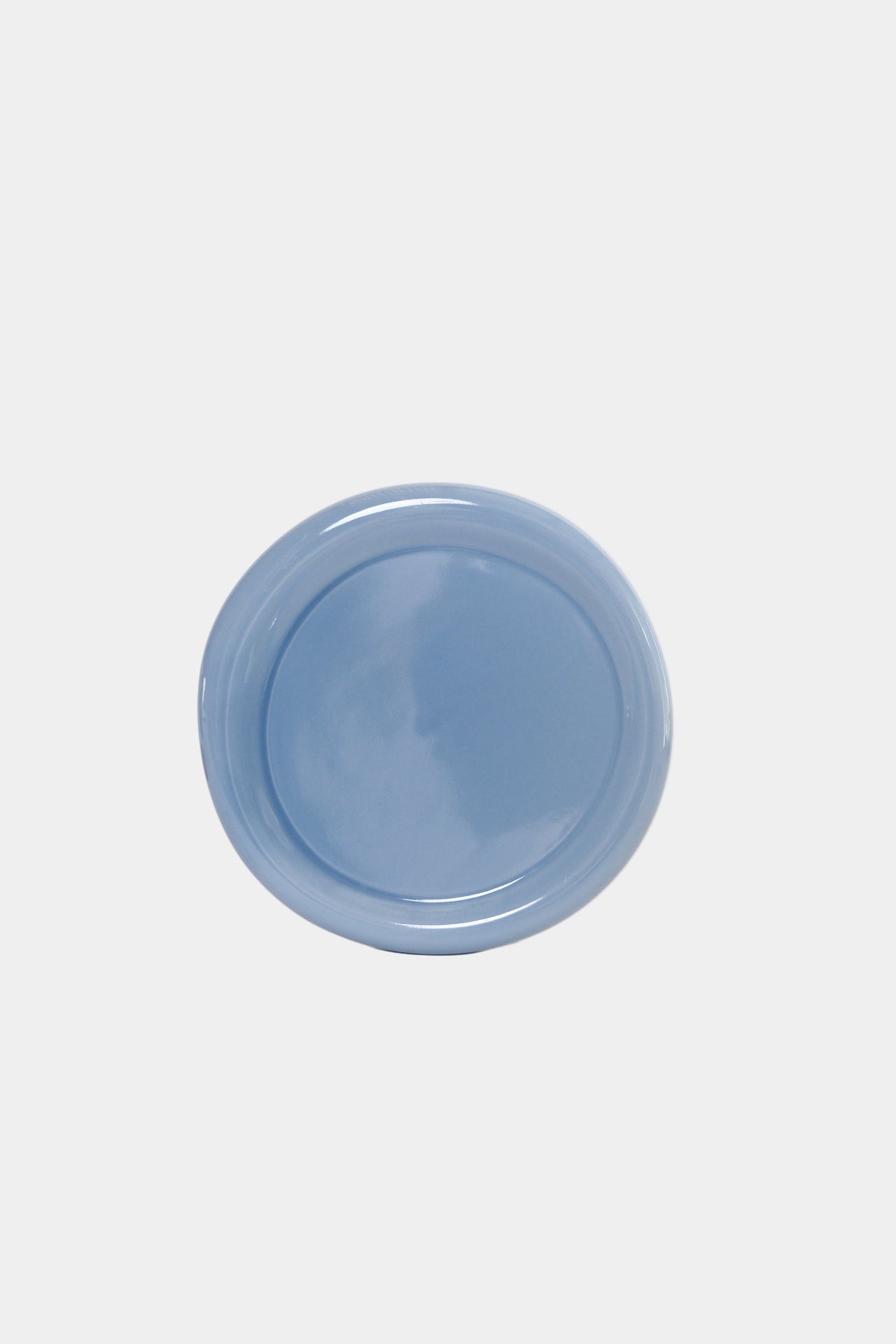 A round ceramic snack plate in a cornflower blue colour on a white background.