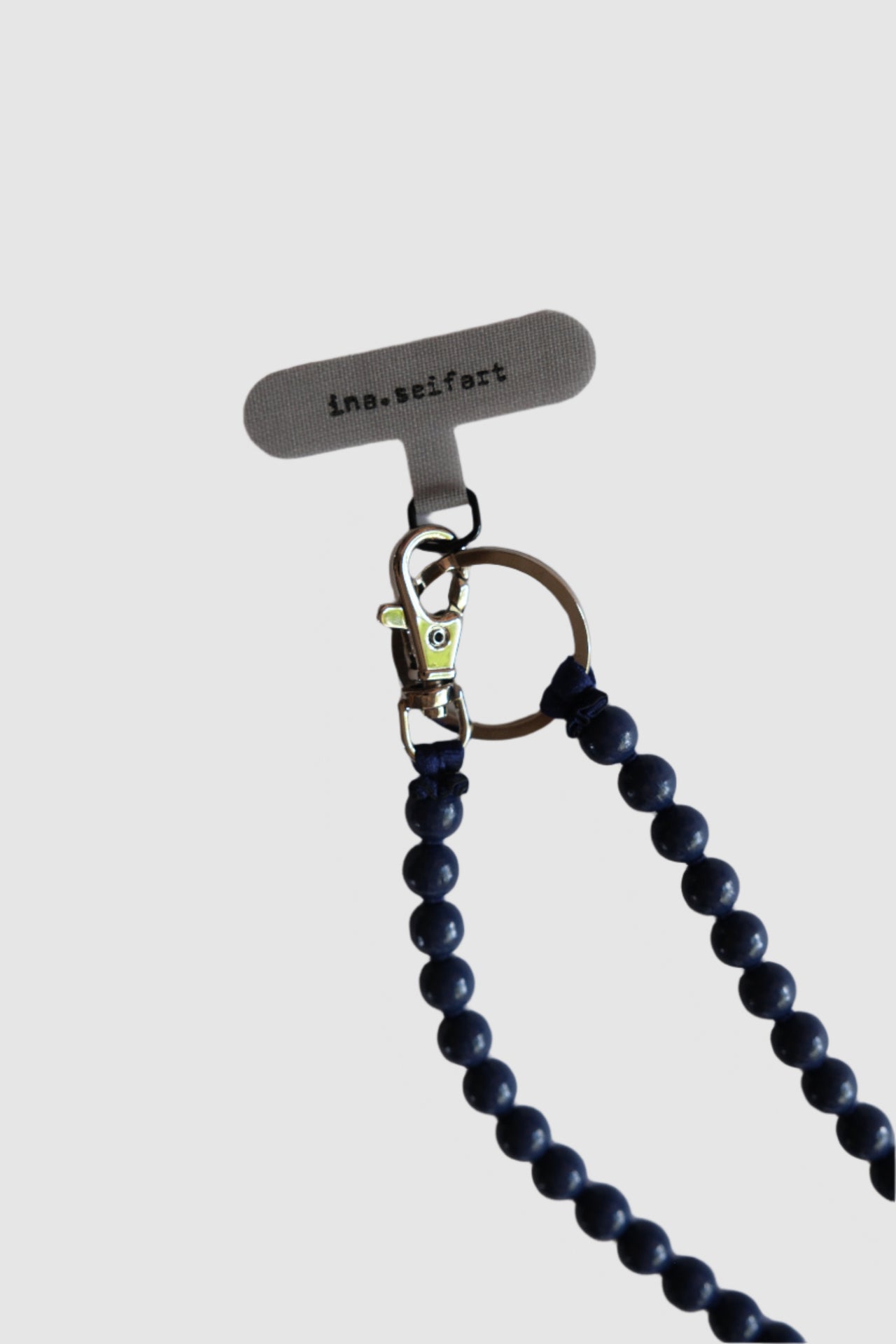 Phone case with blue beaded necklace on a white background