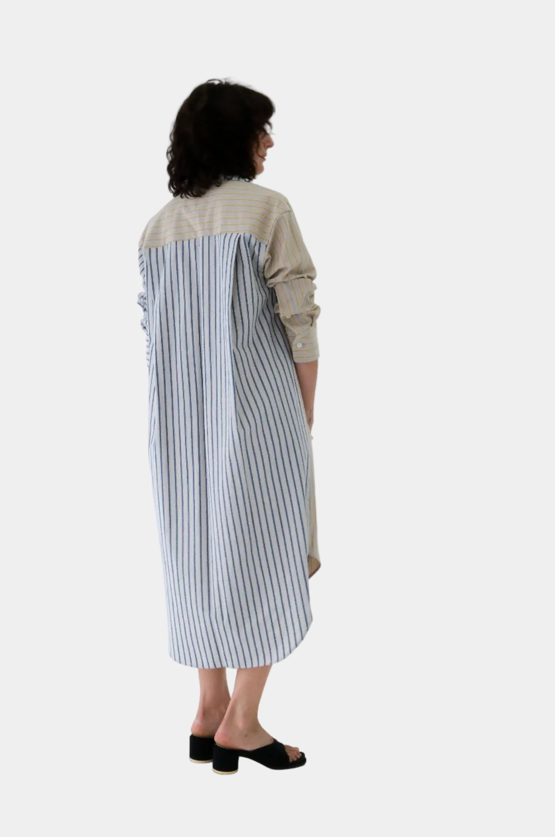 Person wearing a long, striped dress on a white background