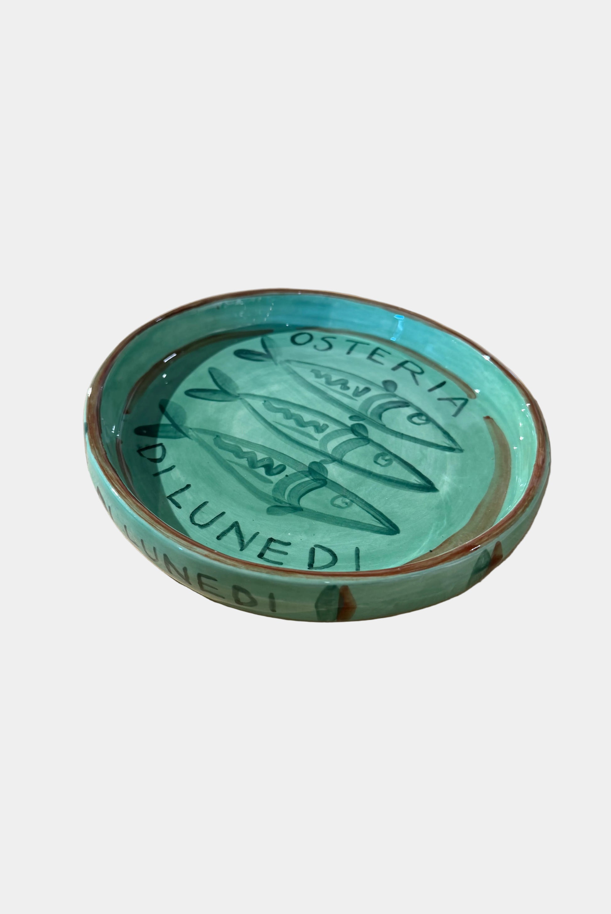 Green ceramic dish with 'Osteria' text on a plain surface