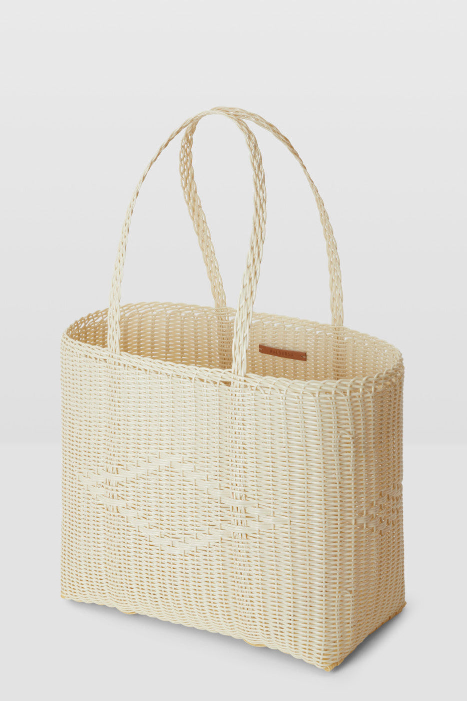 Woven basket with handle on a light gray background