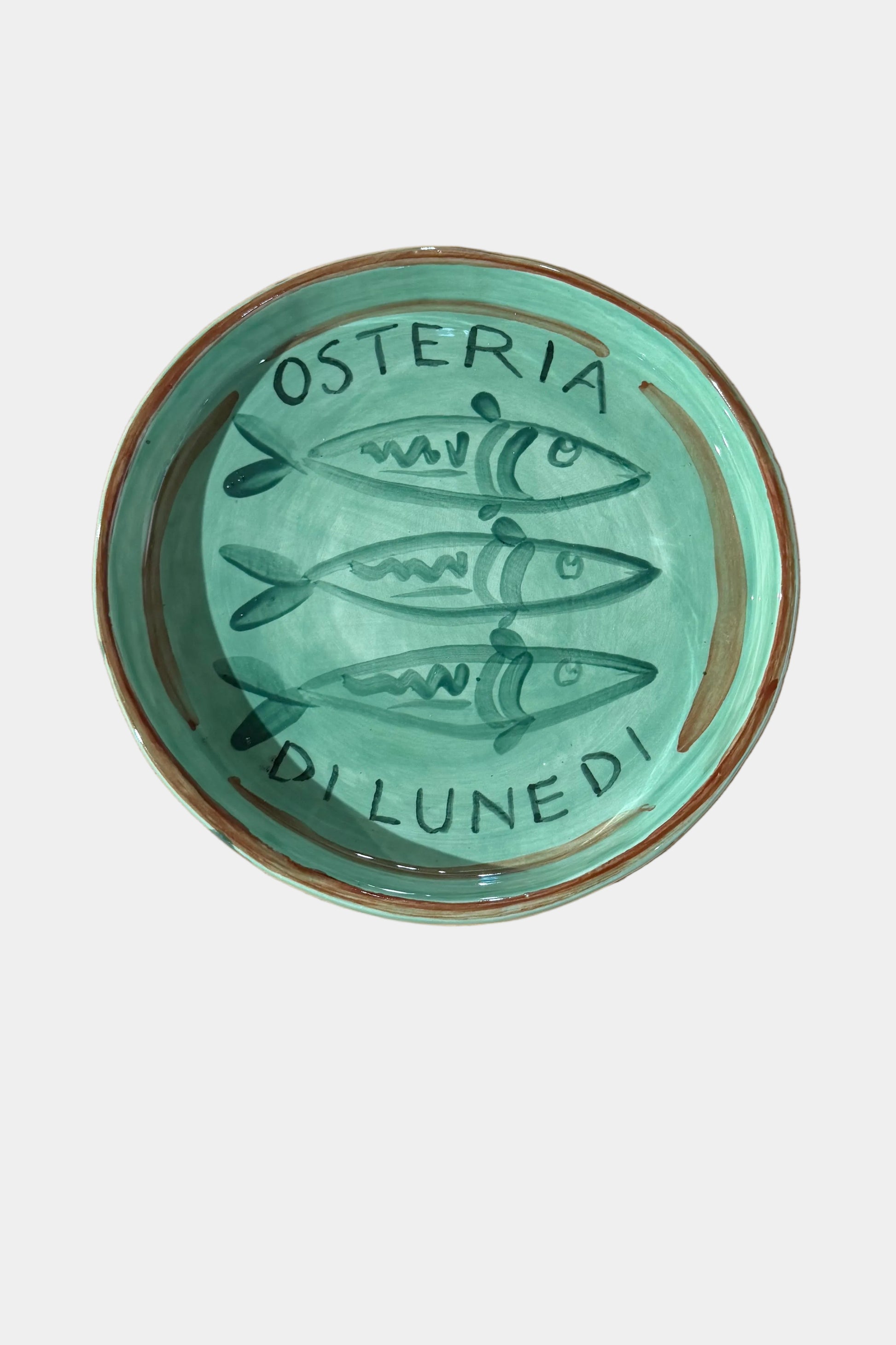 Green coaster with 'Osteria D'Innedi' design on a plain surface