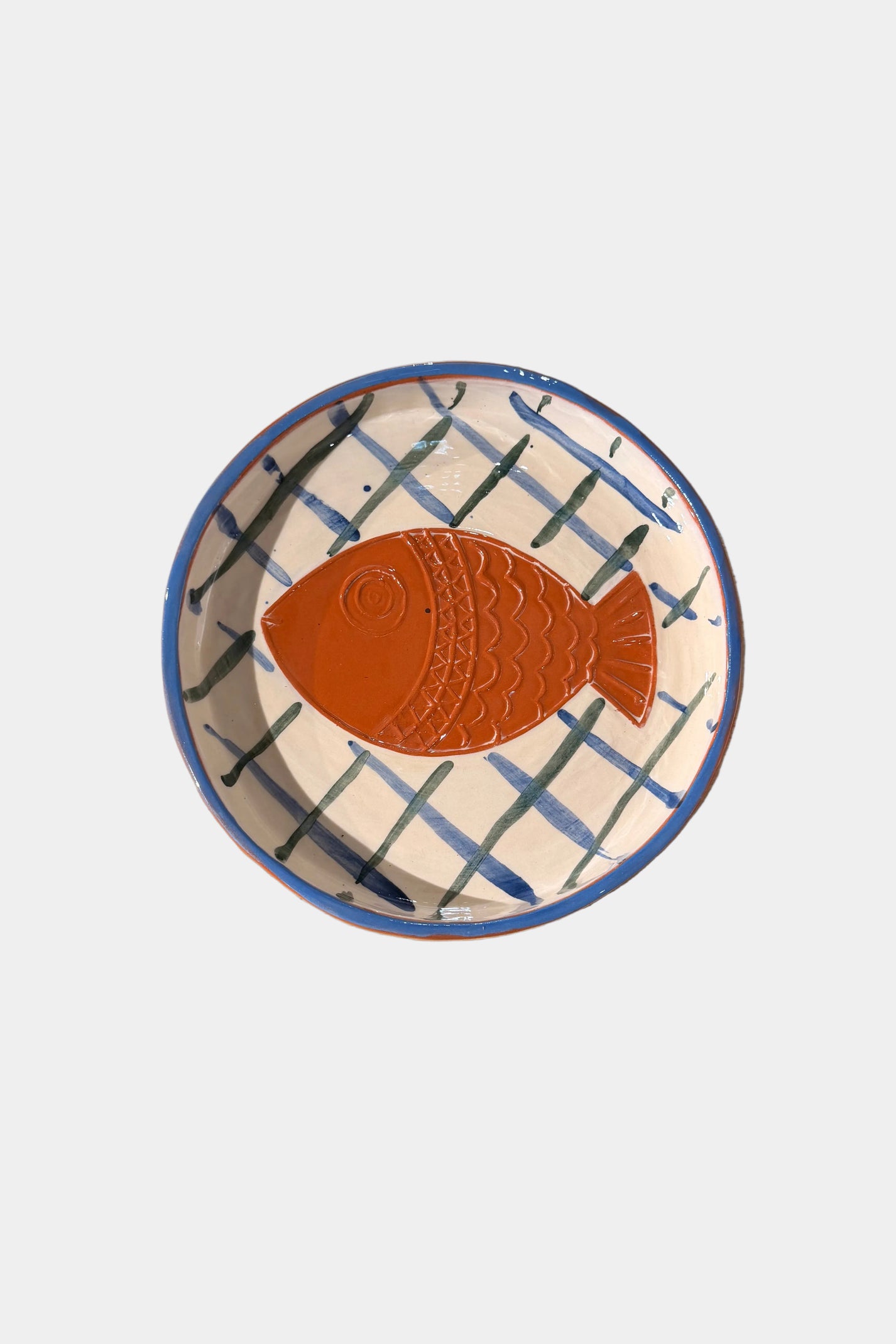 Ceramic plate with a fish design on a plain surface