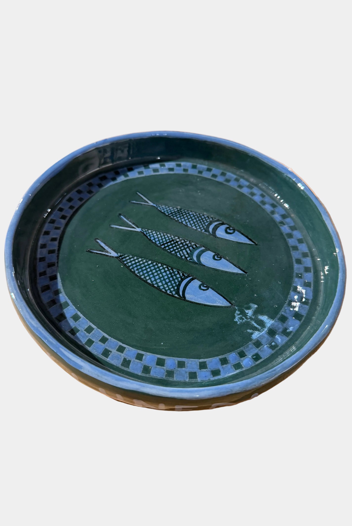 Ceramic plate with fish design on a plain surface