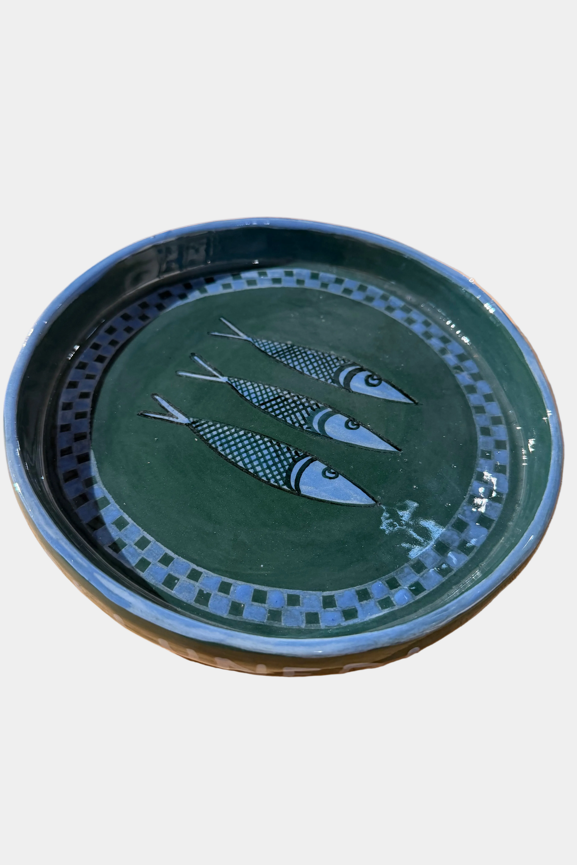 Ceramic plate with fish design on a plain surface