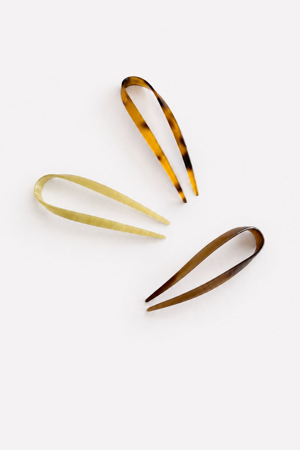 Three hair claw clips in tortoiseshell, solid sage, and solid brown, arranged diagonally on a clean white background - East Coast General
