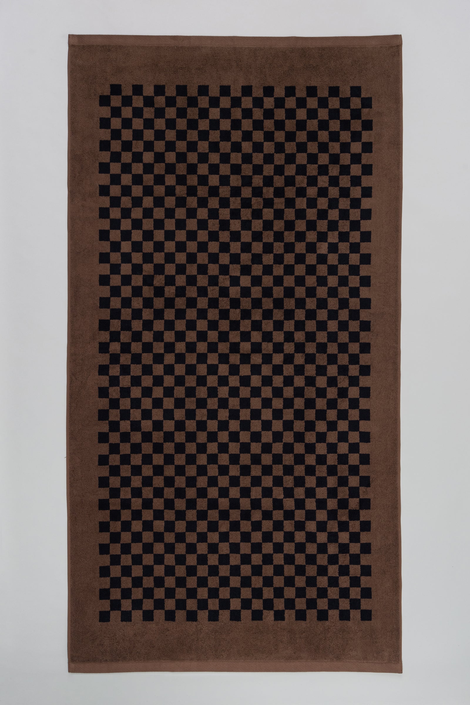 Brown towel with black checkered pattern on a white background
