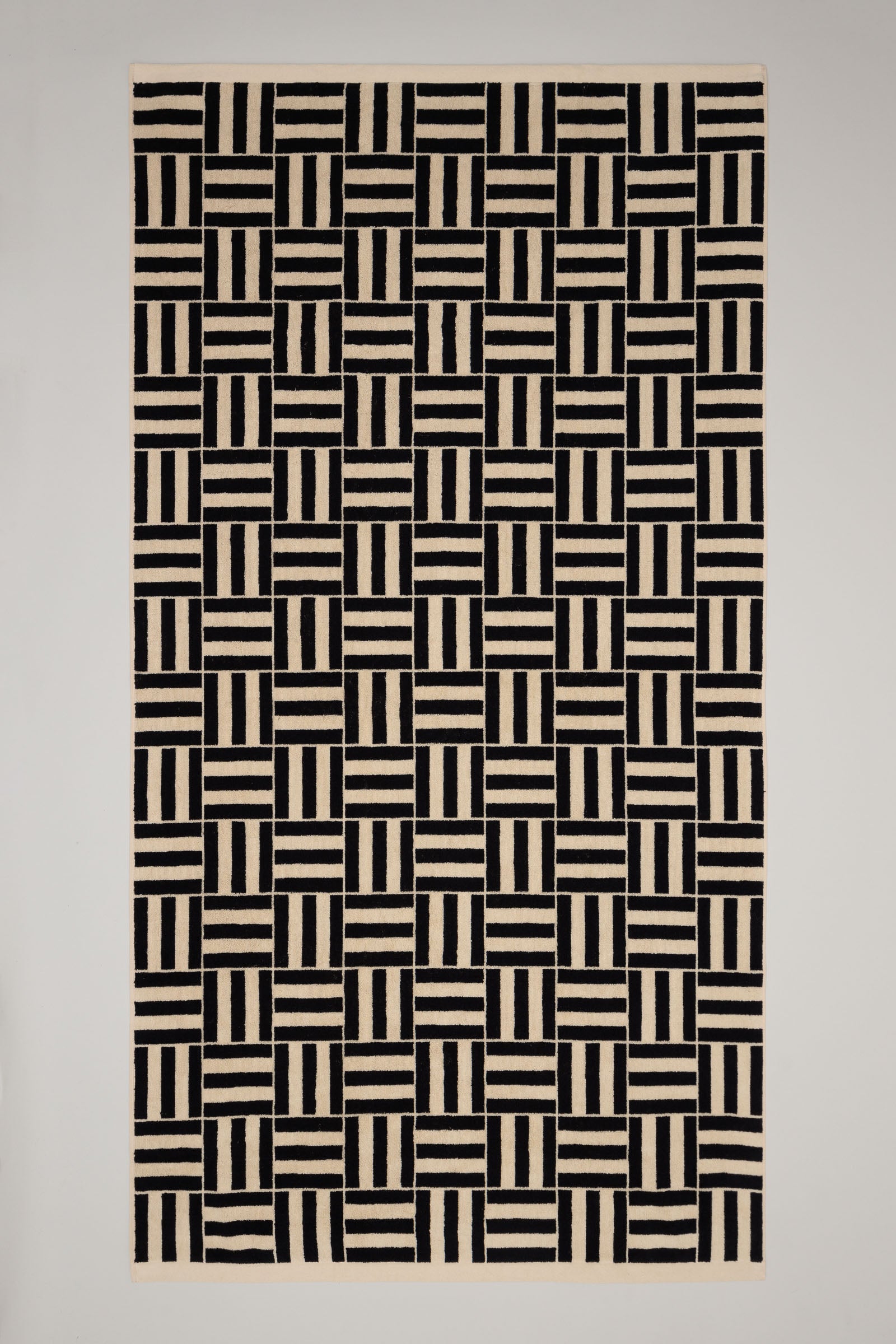 Towel with black and beige geometric pattern on a plain background