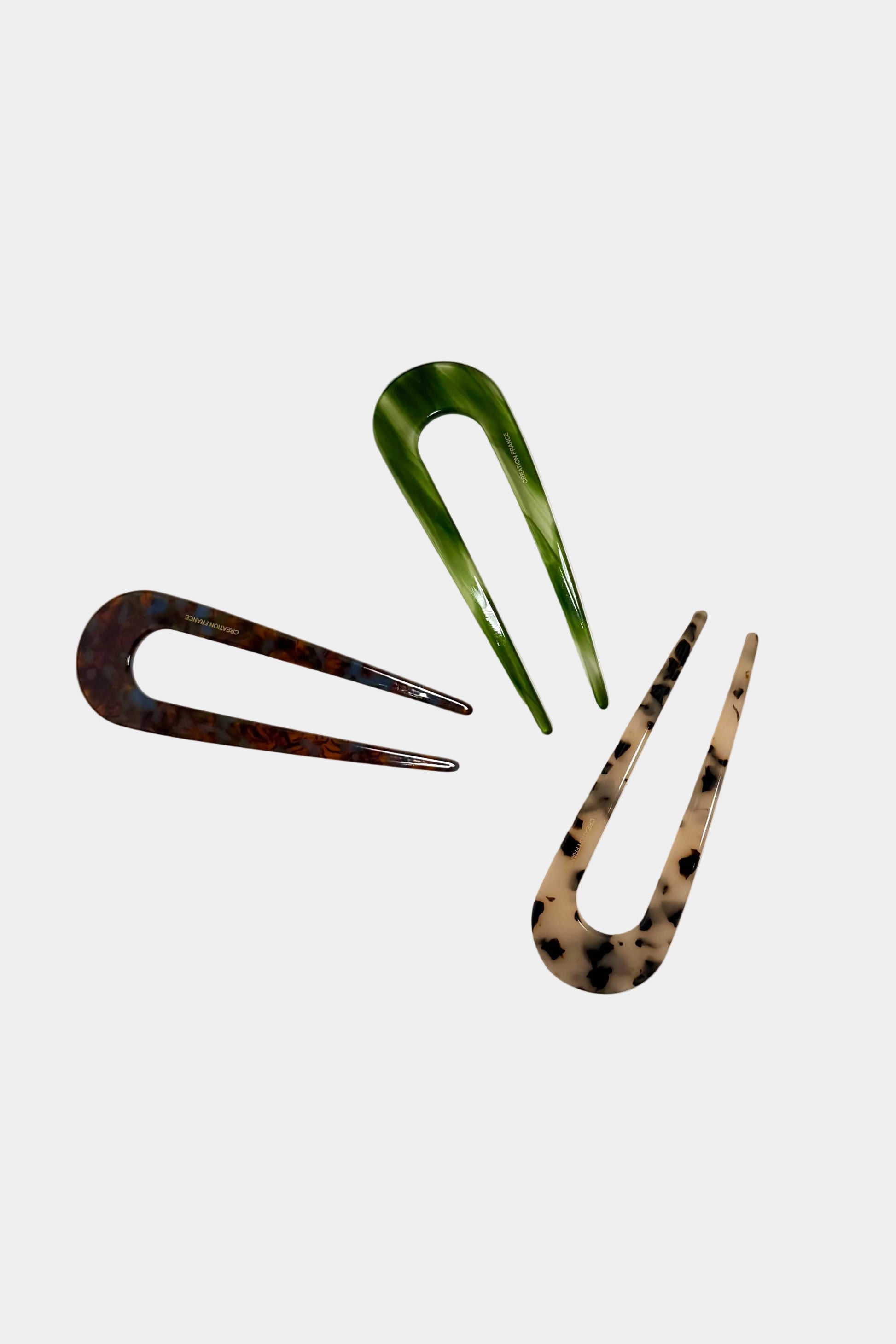 Three hair clips in different colours on a light background