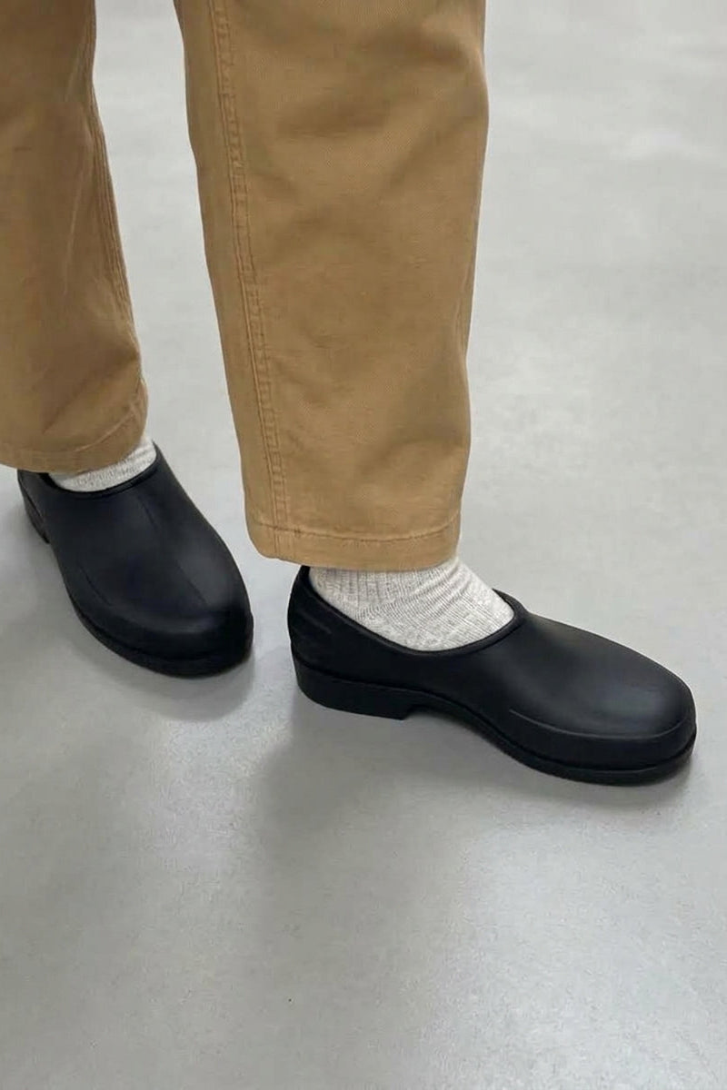 Close up of person wearing the Plasticana Gardenia Clogs in Noir with tan trousers and socks - East Coast General