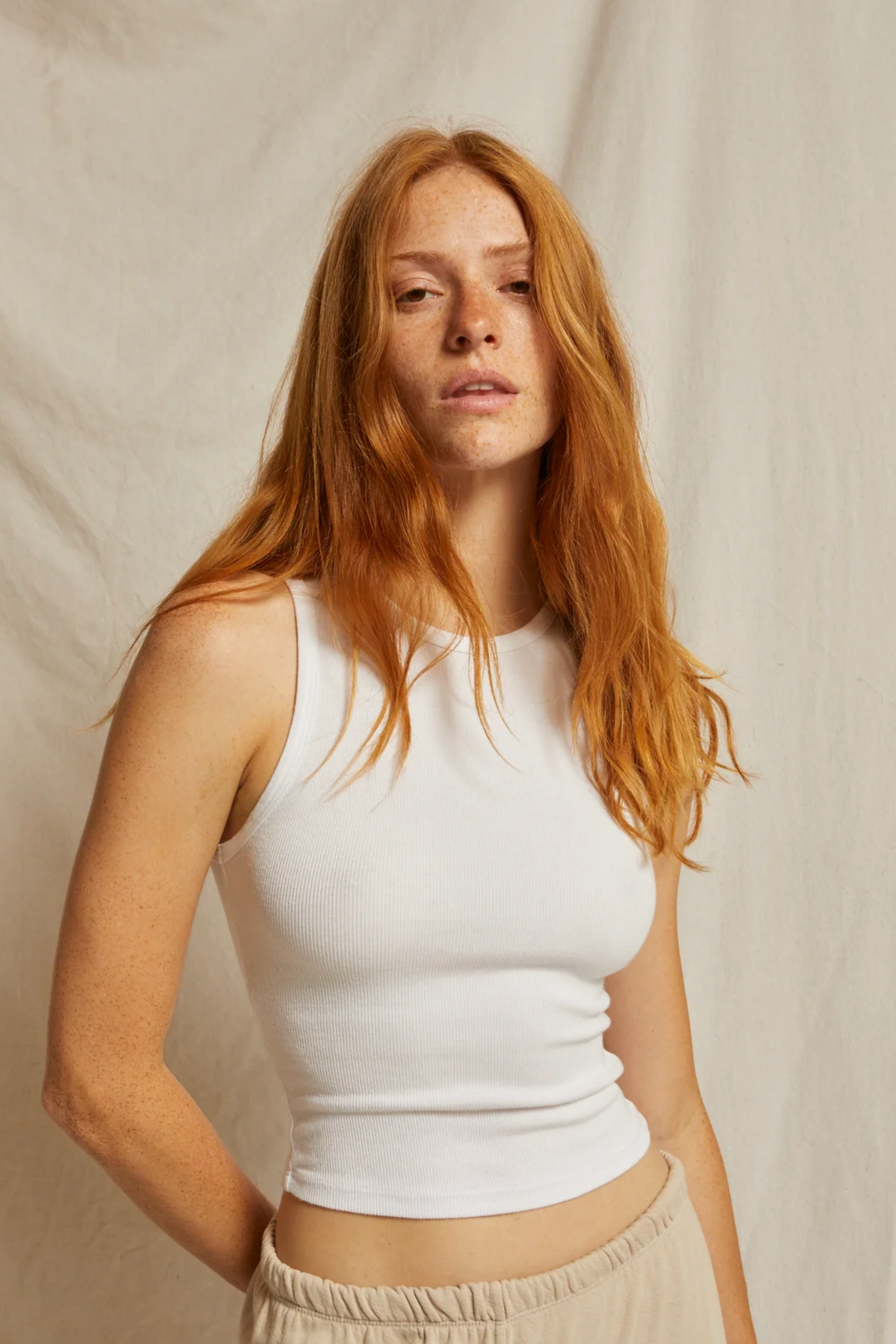 Lady wearing a white high neck ribbed tank
