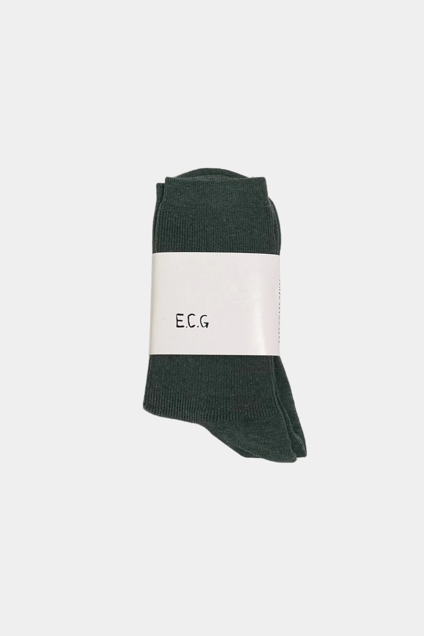 Dark green socks with a white label on a light gray background